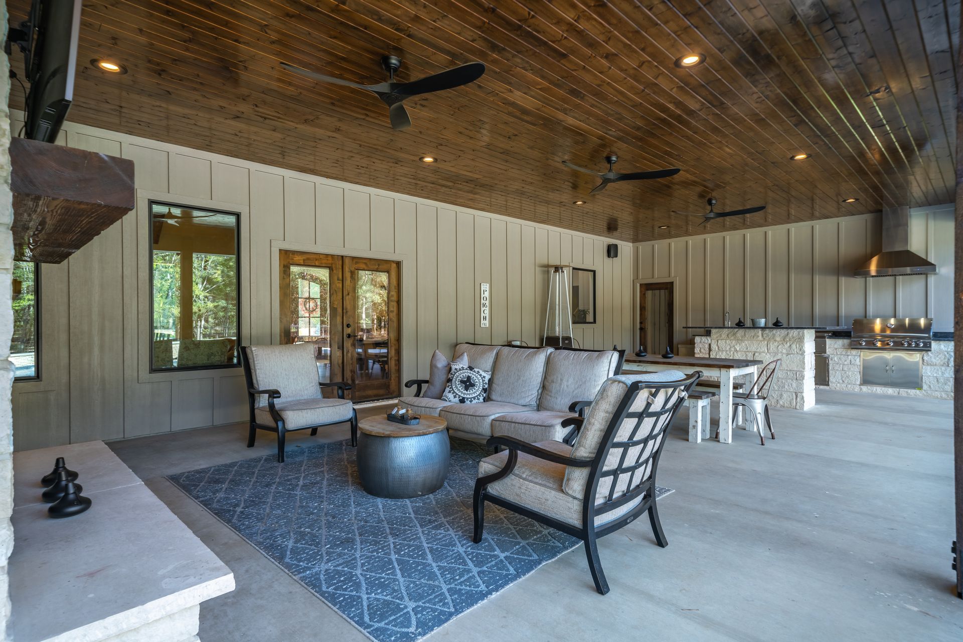 A living room with a couch , chairs , a table and a ceiling fan.