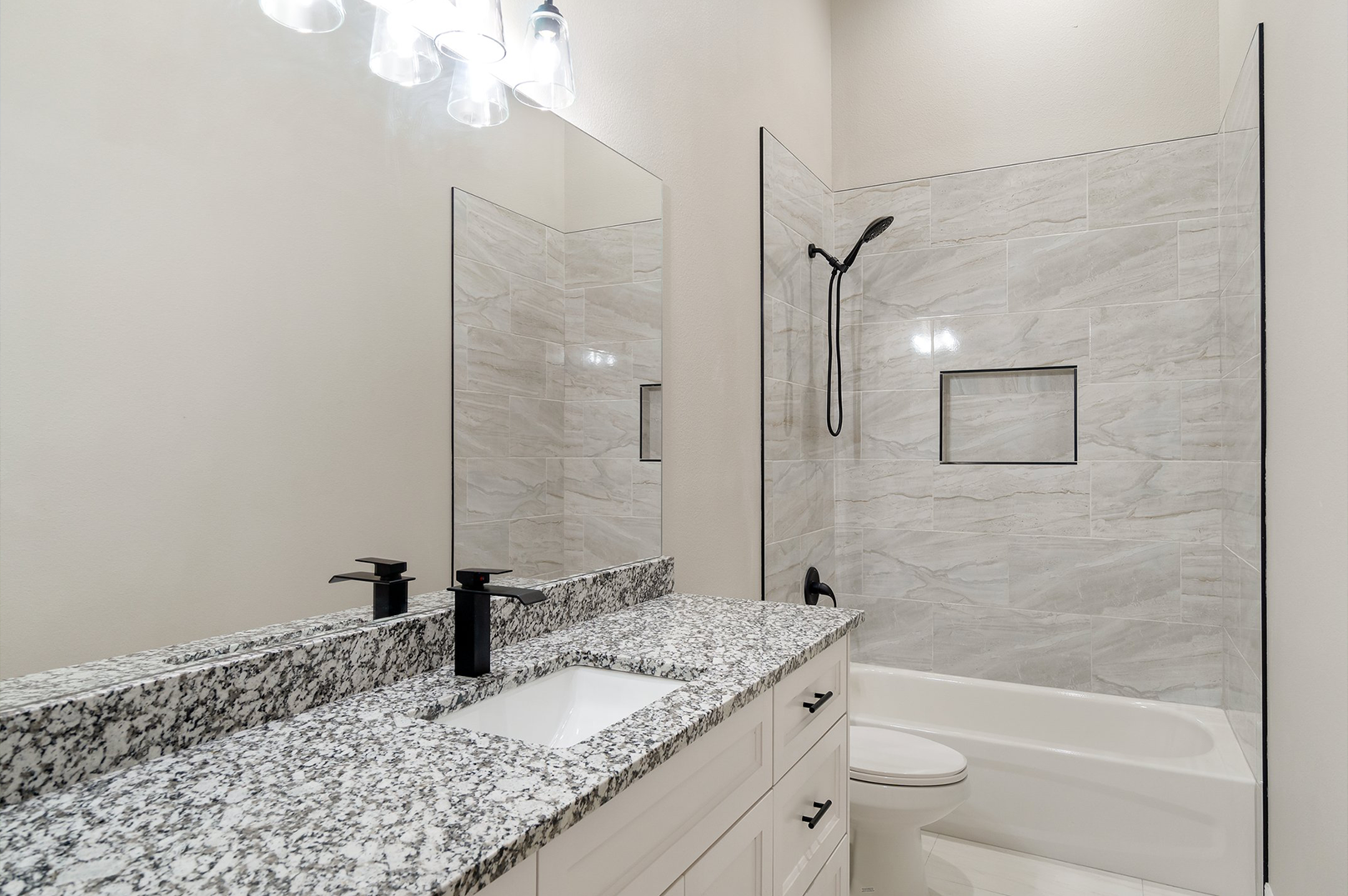 A bathroom with a sink , toilet , shower and bathtub.