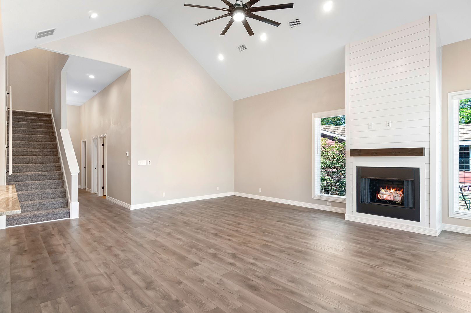 An empty living room with hardwood floors and a fireplace.