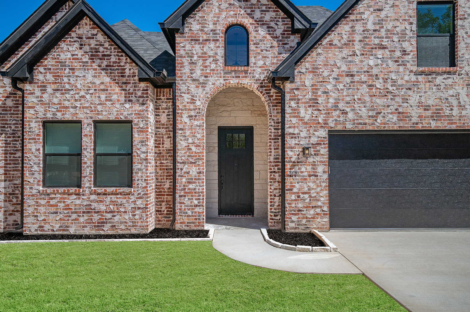 A large brick house with a black garage door