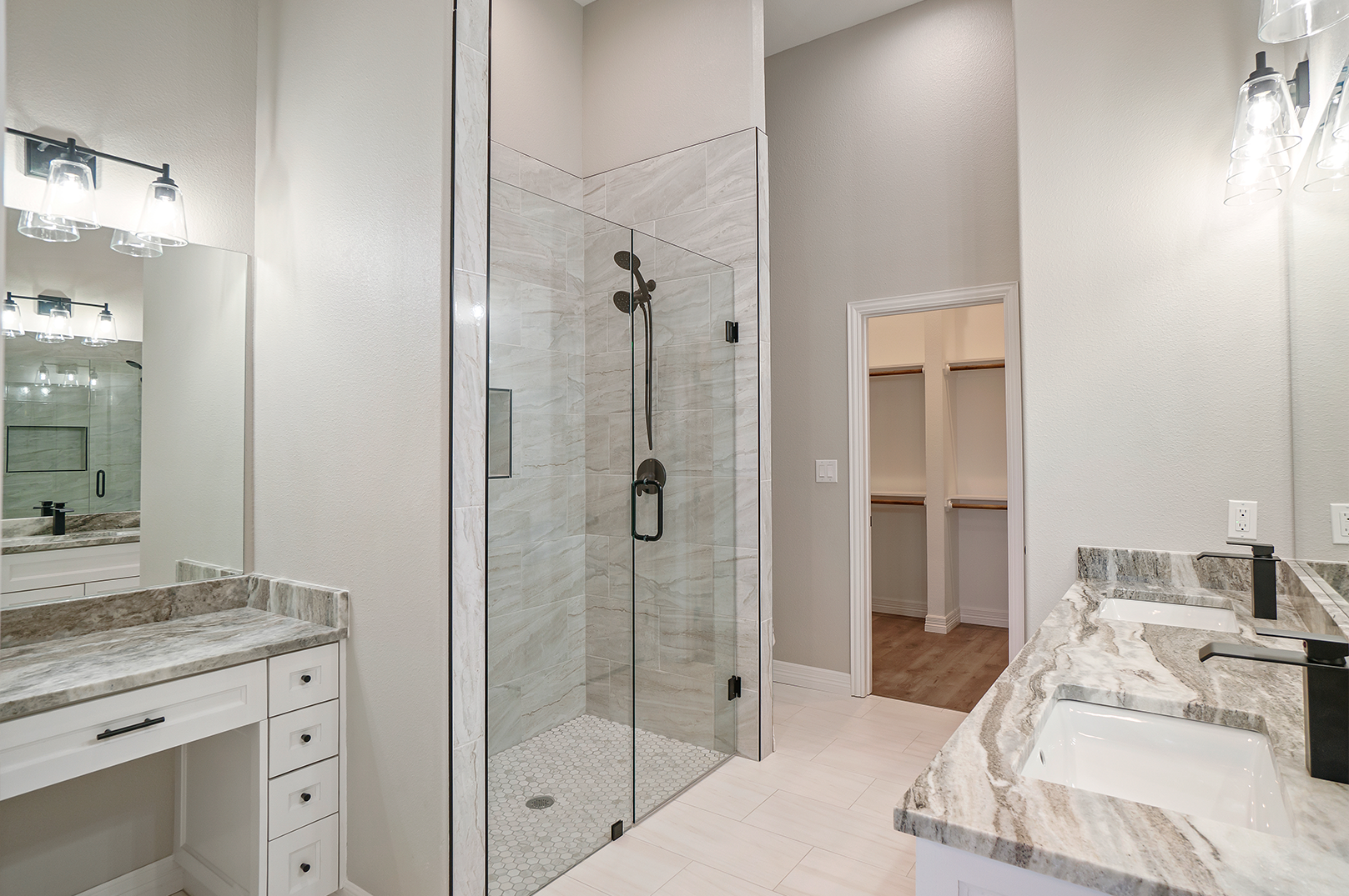 A bathroom with two sinks and a walk in shower.