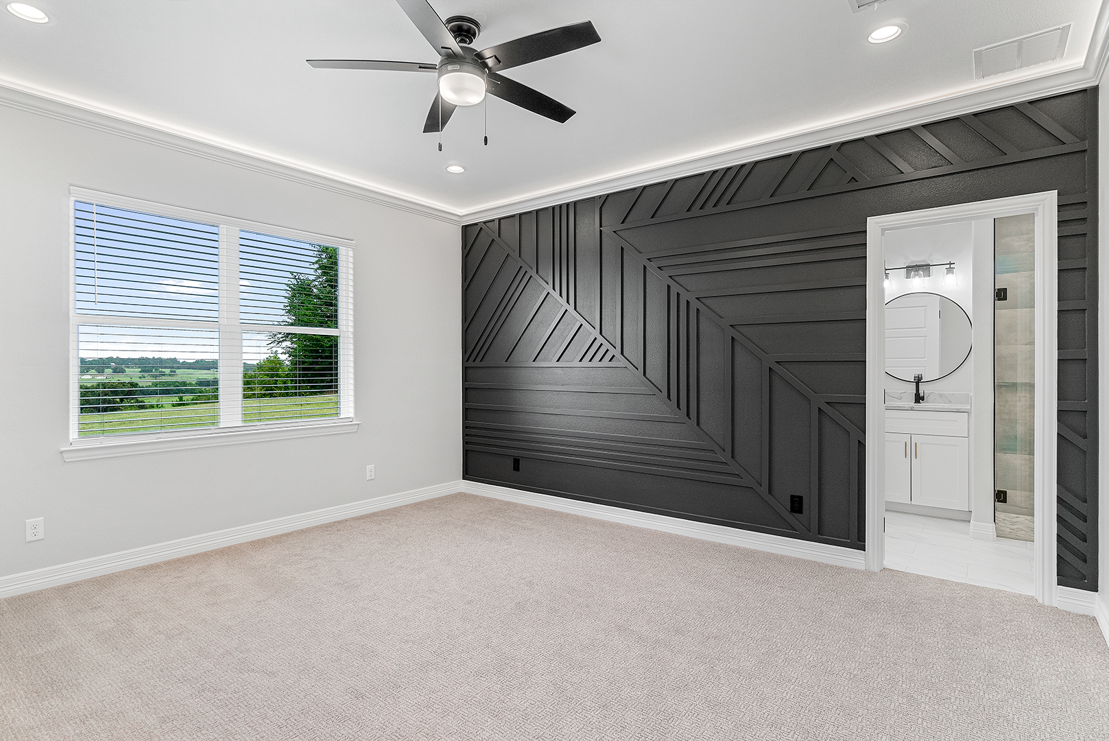 An empty bedroom with a ceiling fan and a black wall.