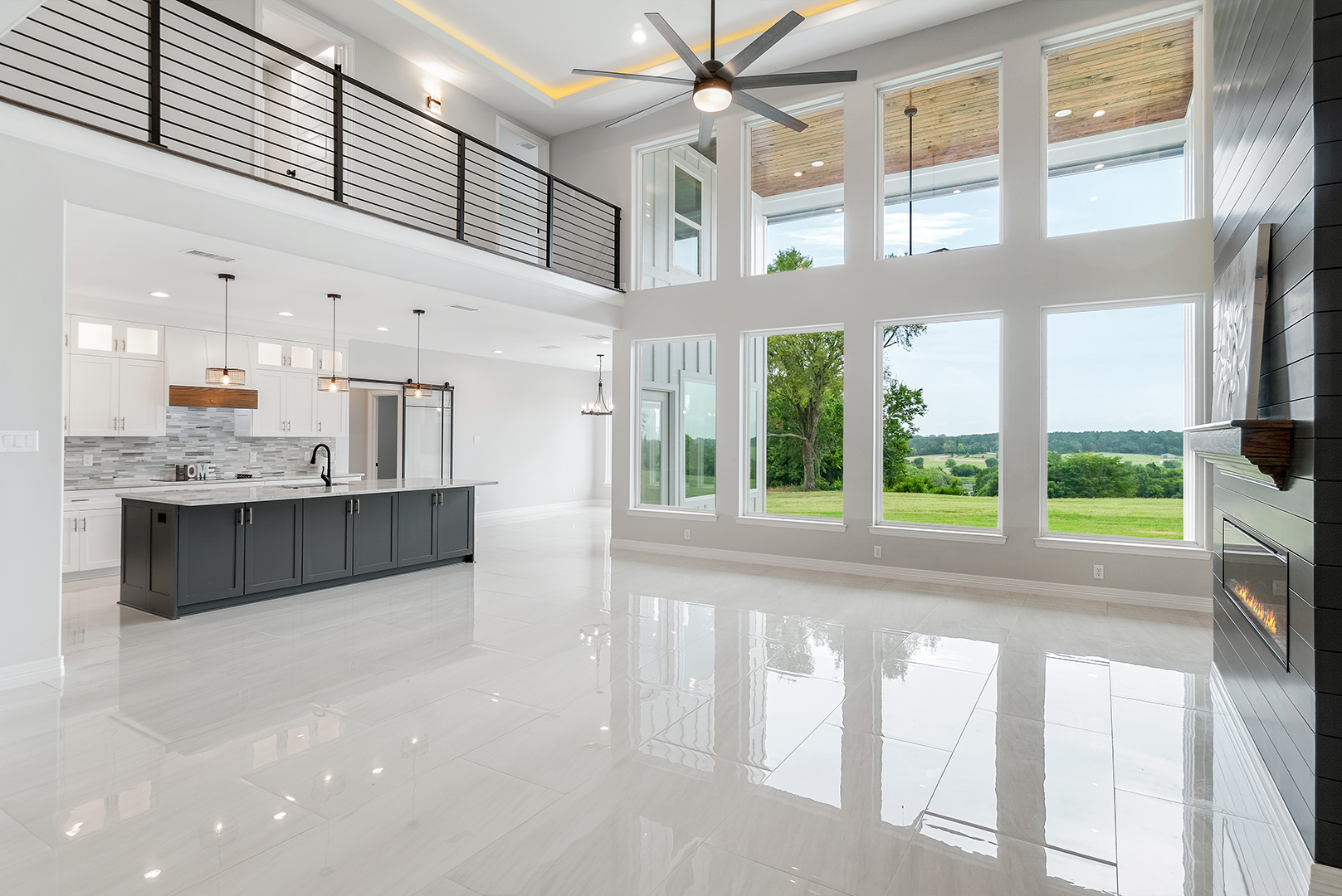 A large empty room with a lot of windows and a ceiling fan.