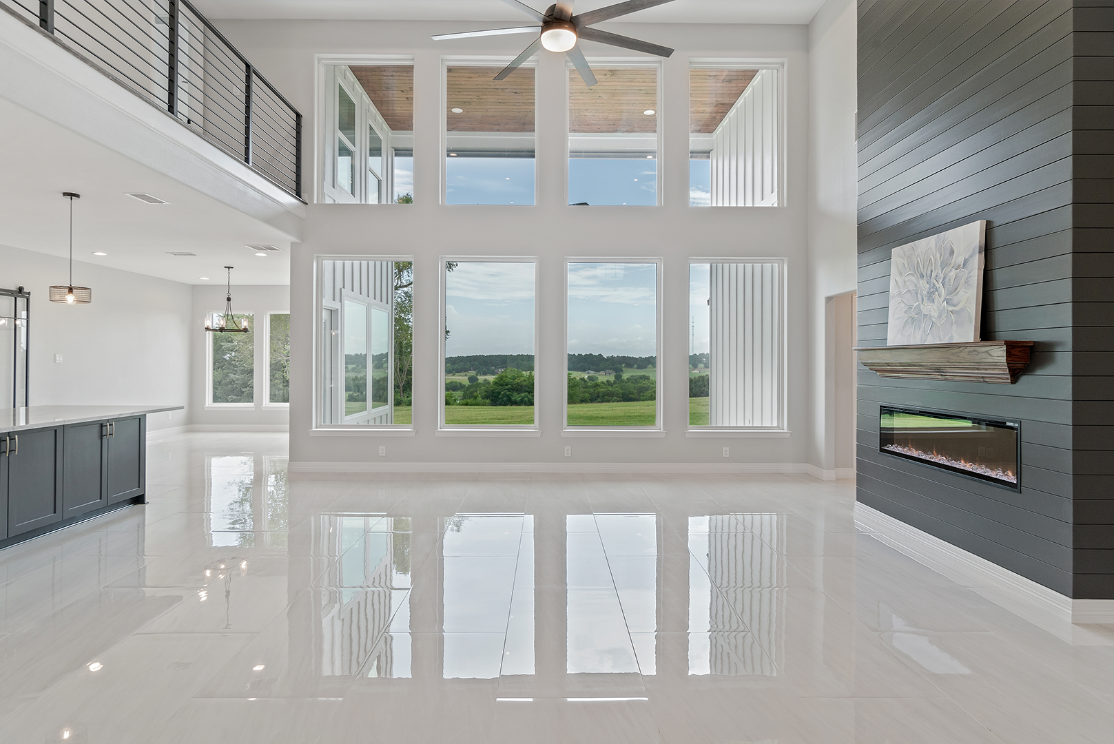 A large empty room with a lot of windows and a fireplace.