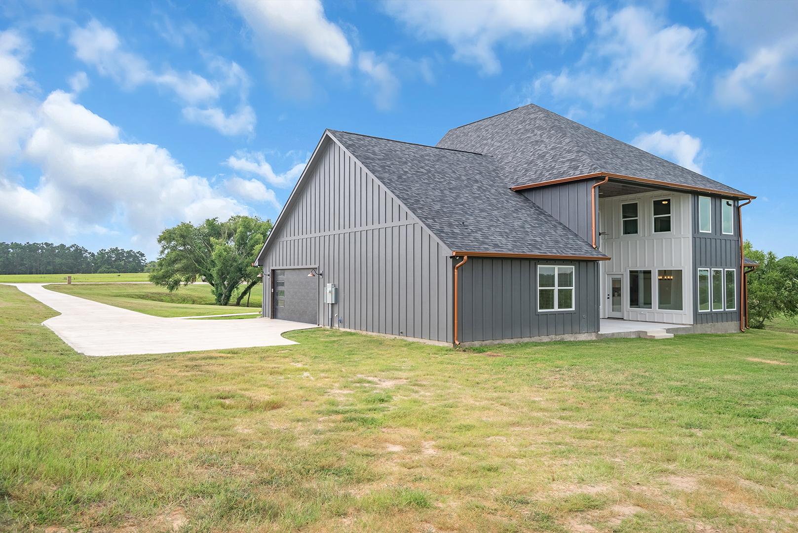 A large house is sitting in the middle of a grassy field.