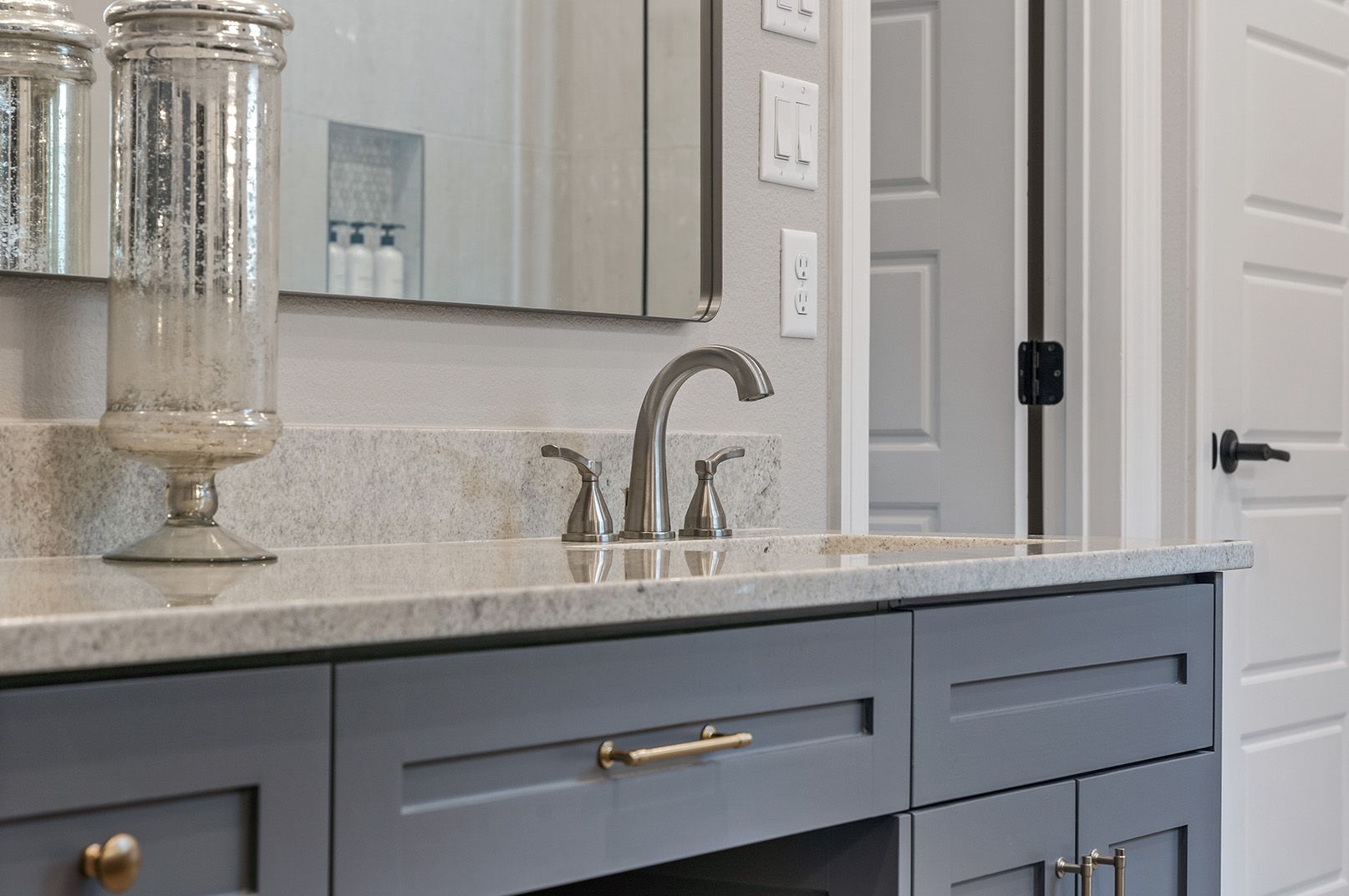 A bathroom vanity with a sink , mirror and drawers.