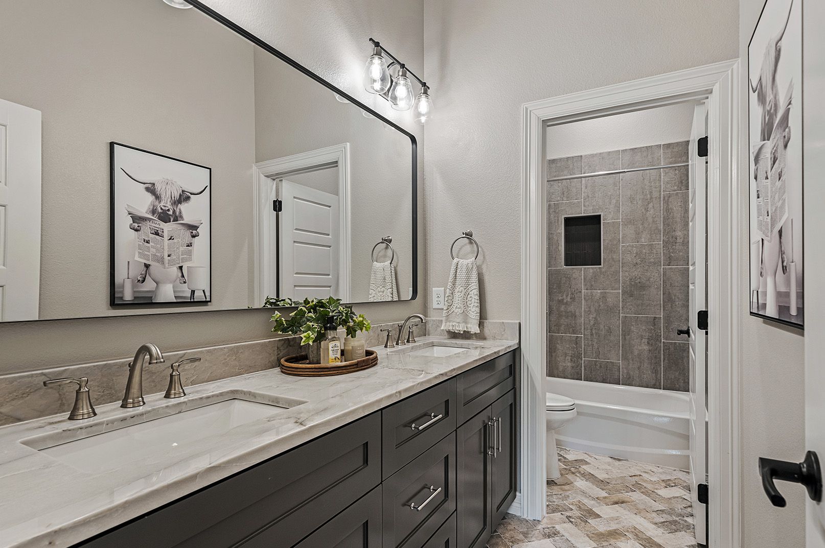 A bathroom with two sinks and a large mirror.