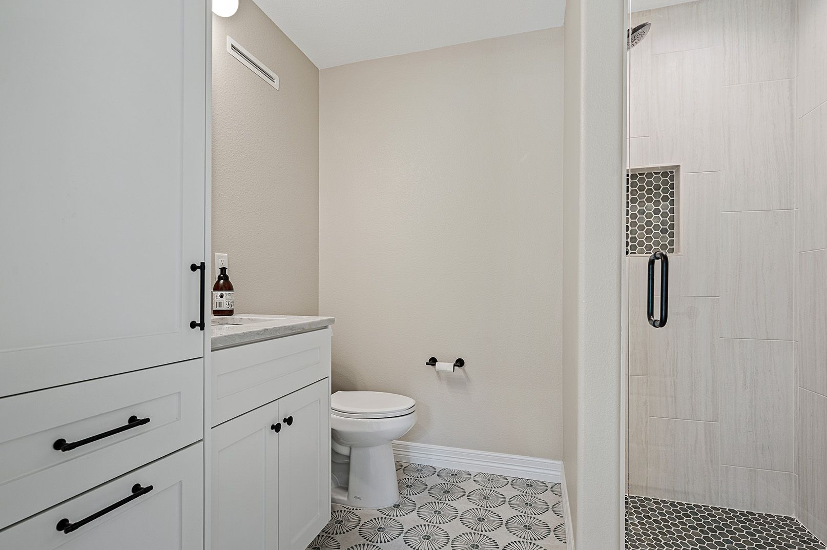 A bathroom with a toilet , sink , and shower.