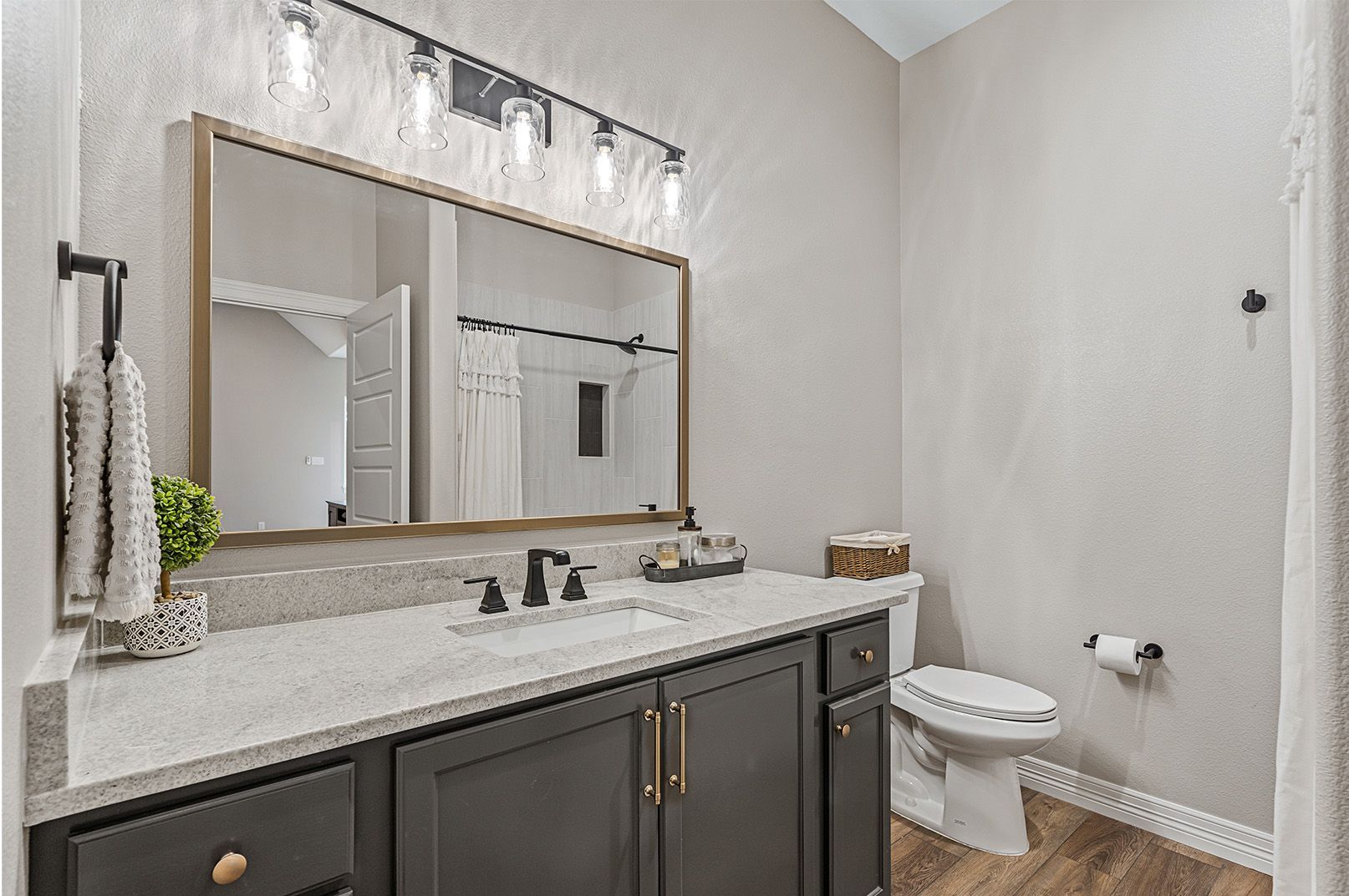 A bathroom with a sink , toilet and mirror.