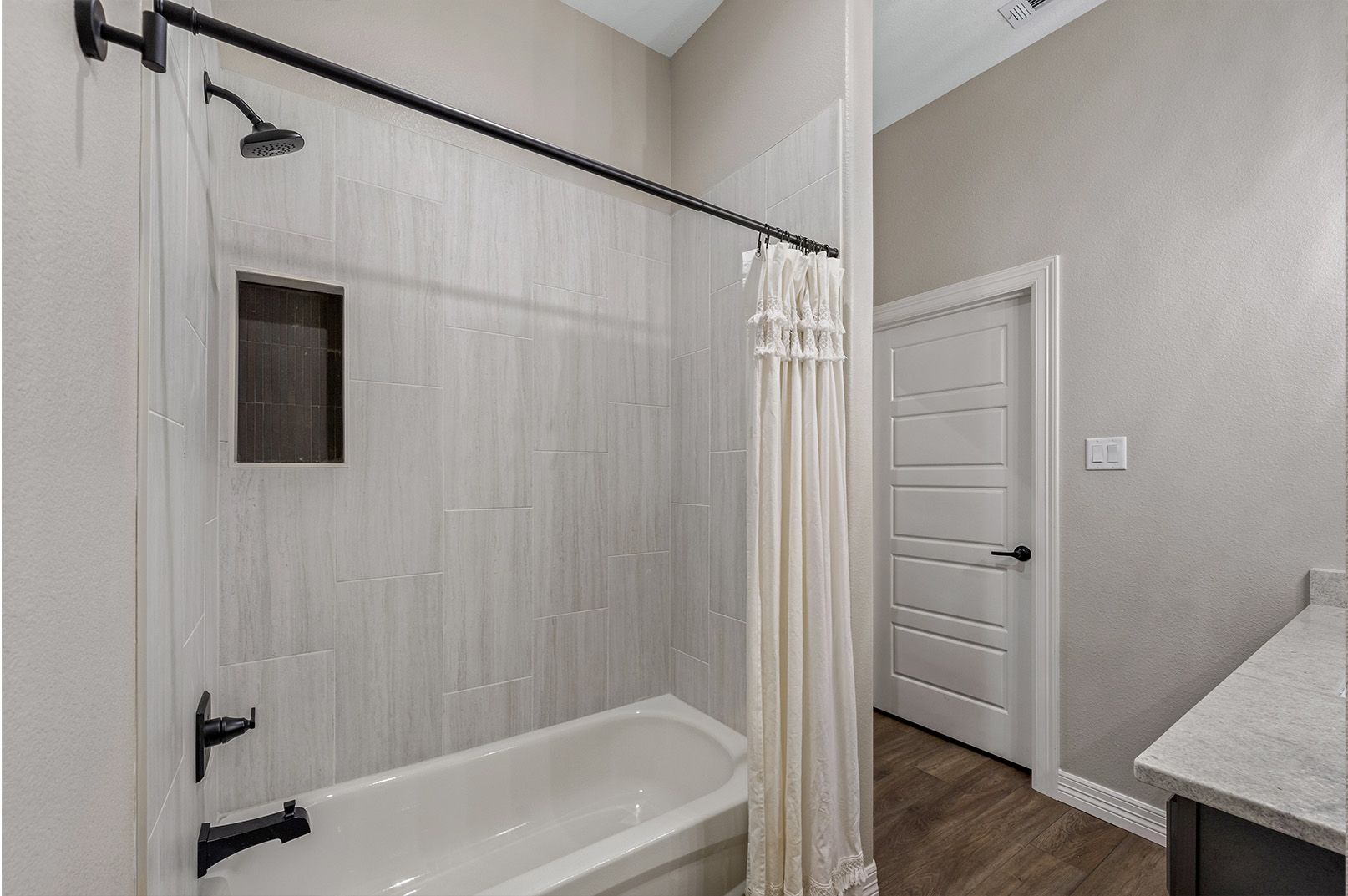 A bathroom with a bathtub , shower and sink.