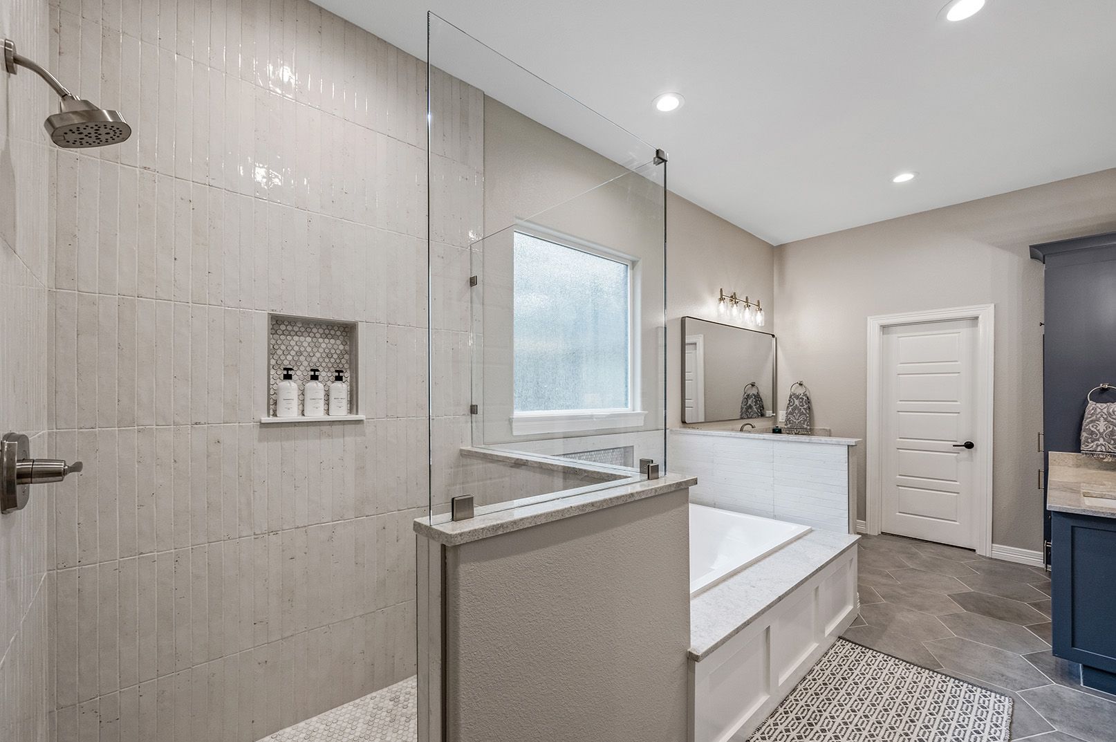 A bathroom with a walk in shower and a bathtub.