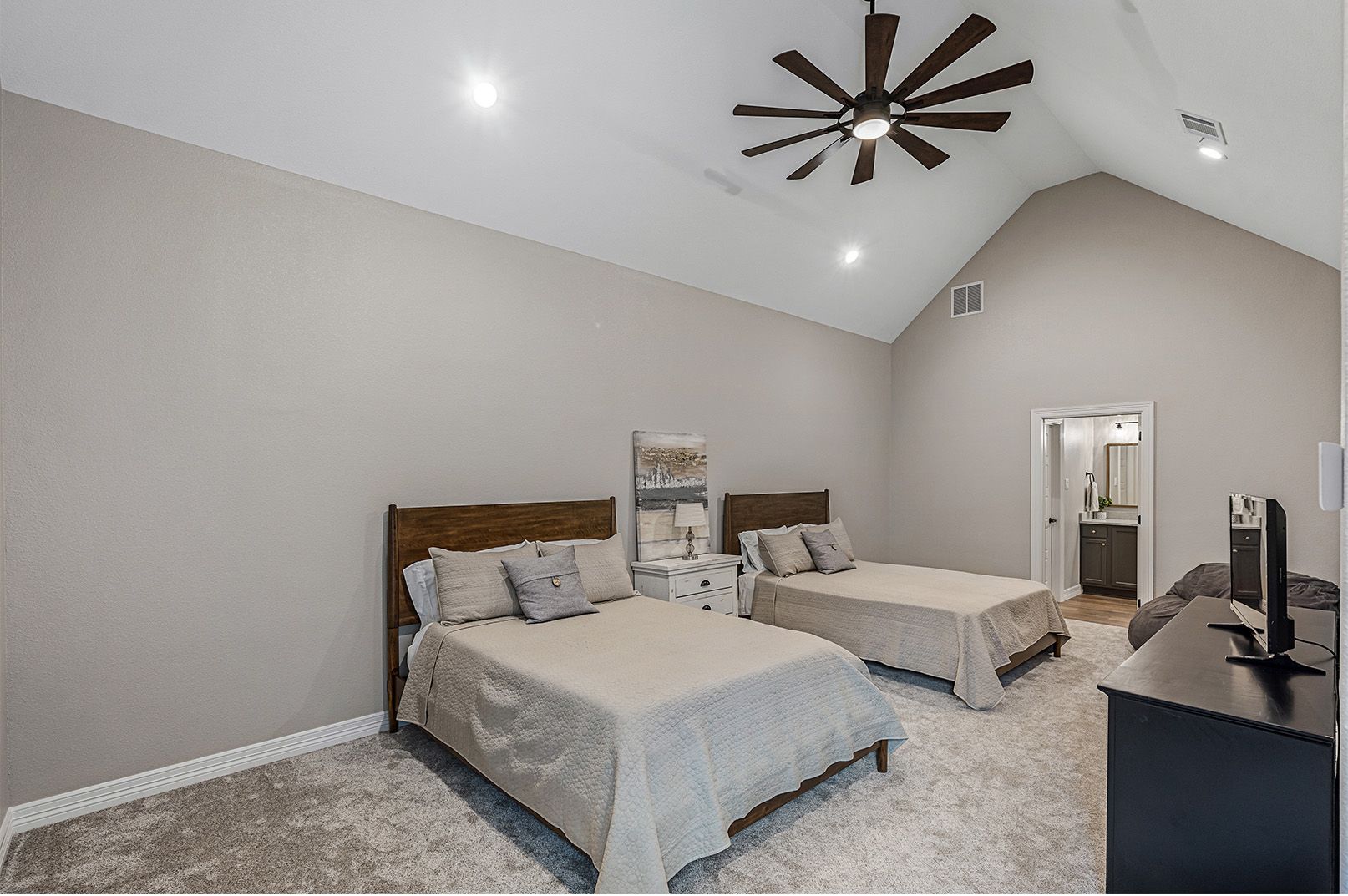 A bedroom with two beds and a ceiling fan.