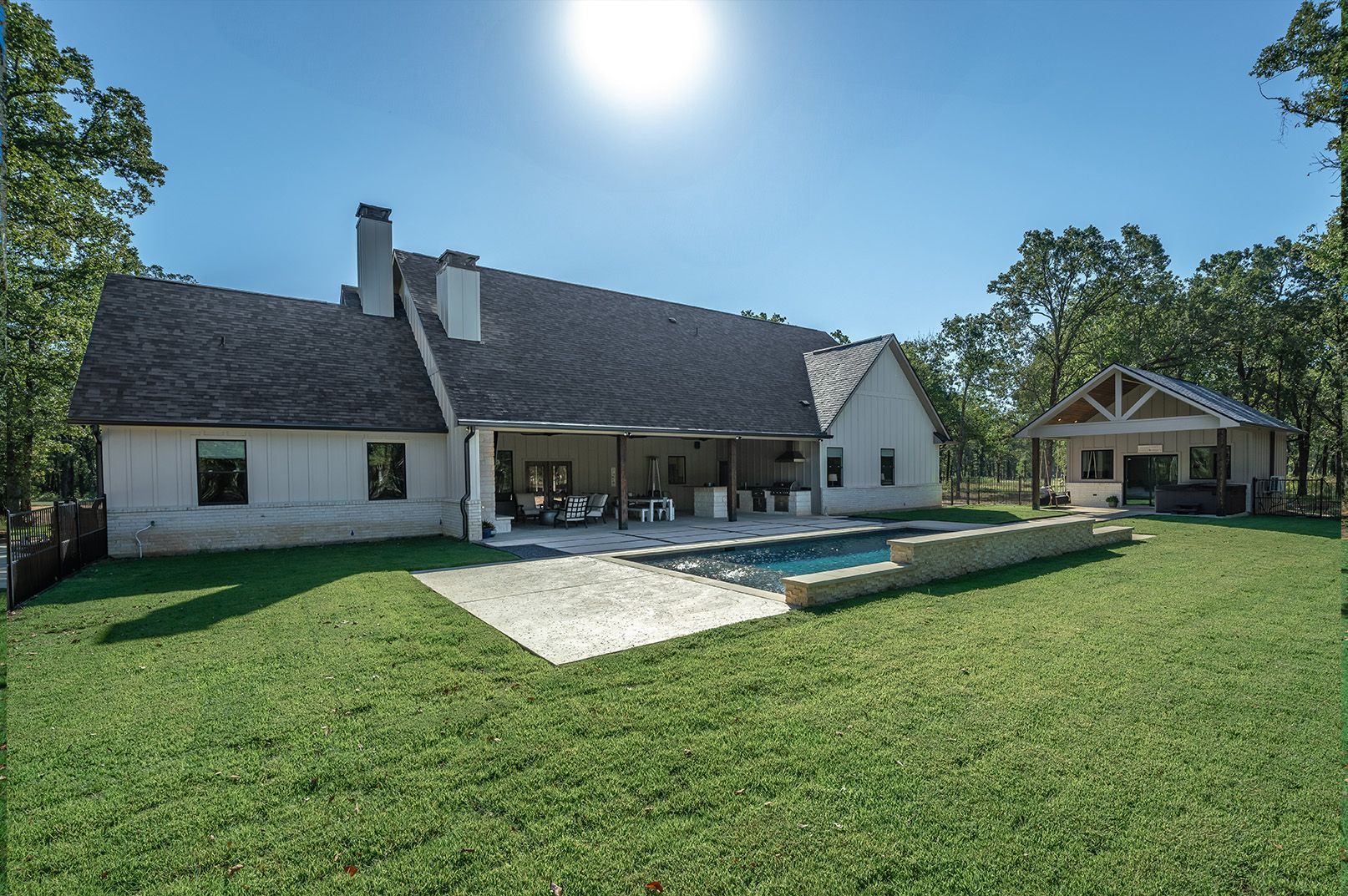 A large white house with a large swimming pool in the backyard.