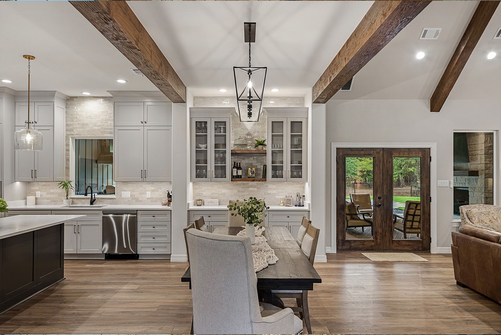 A kitchen and dining room in a house with wooden beams.