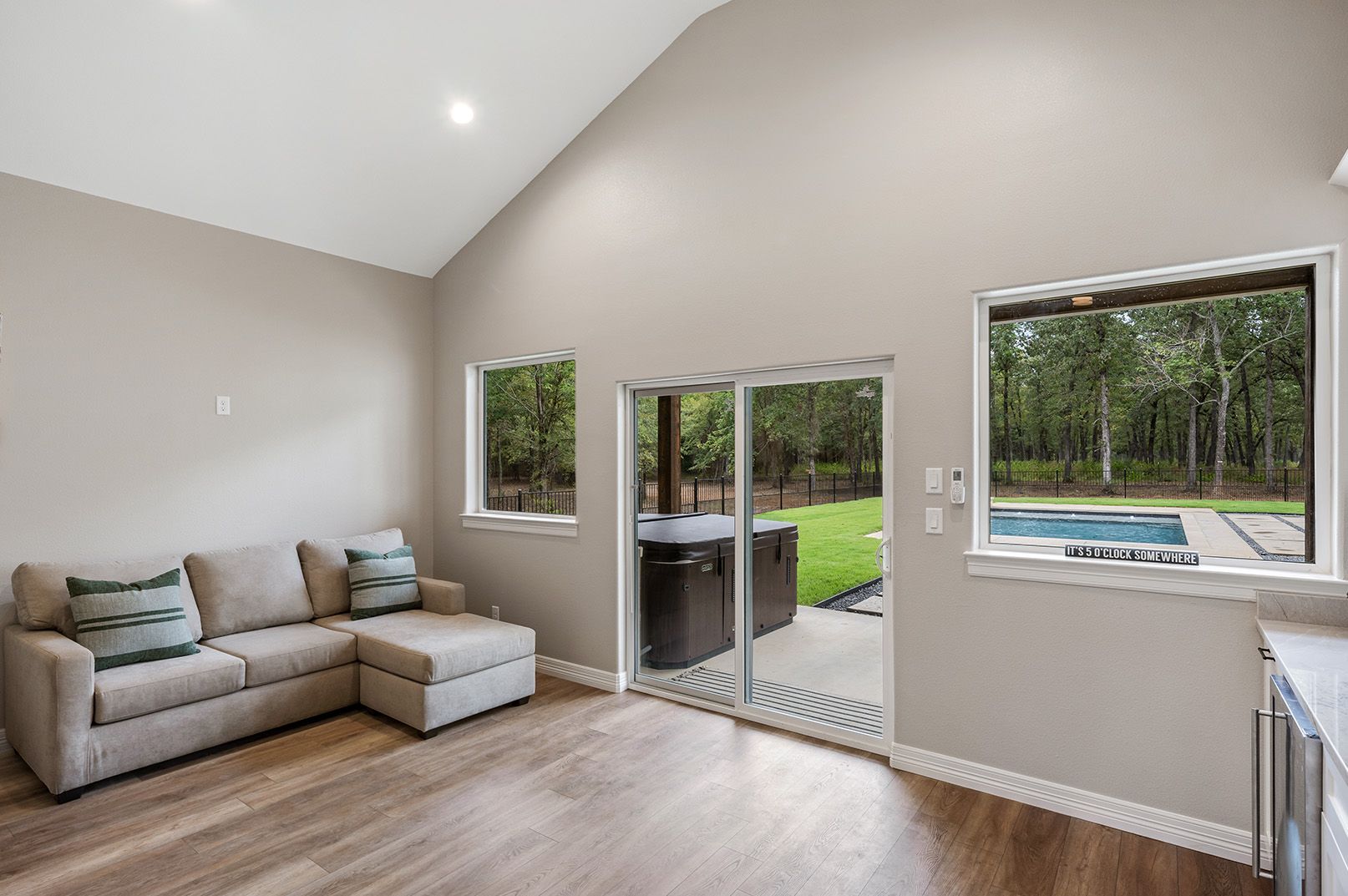 A living room with a couch and sliding glass doors leading to a pool.