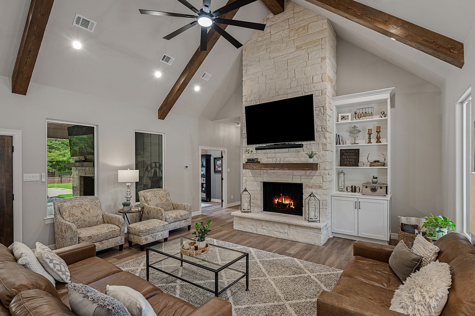 A living room with a couch , chairs , a fireplace and a flat screen tv.
