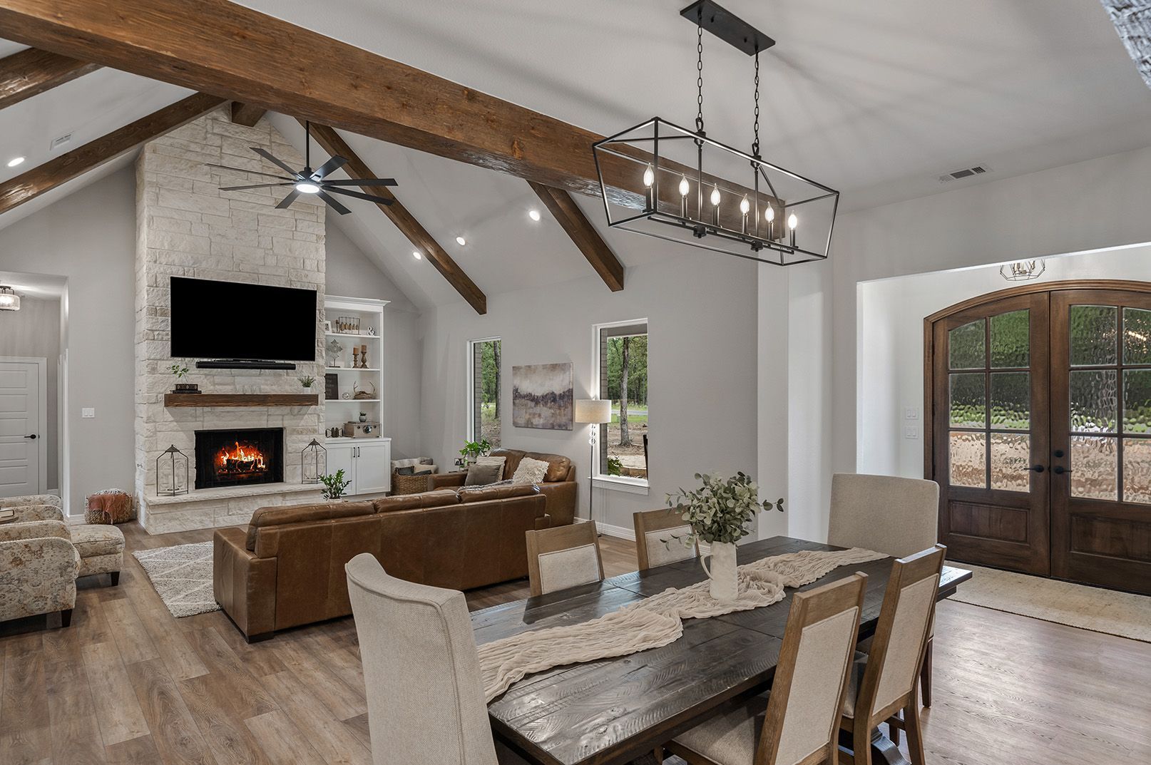 A living room with a dining table and chairs and a fireplace.
