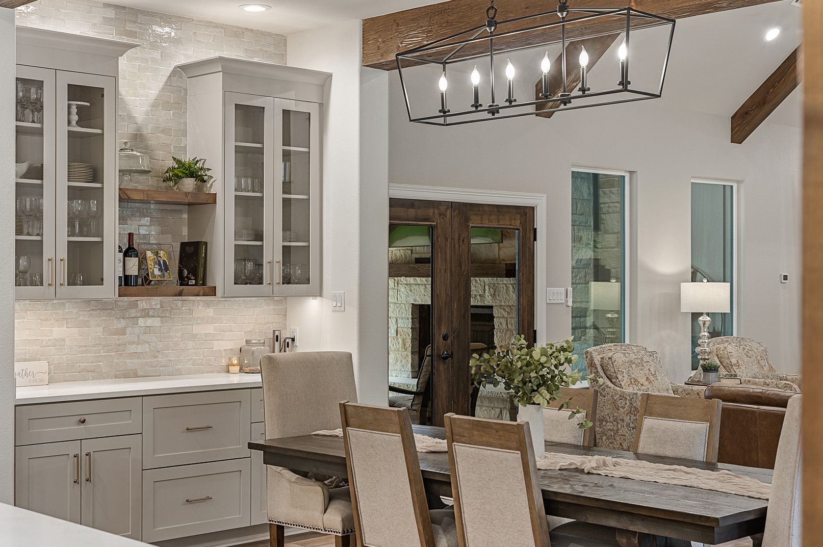 A kitchen with a dining table and chairs and a chandelier hanging from the ceiling.