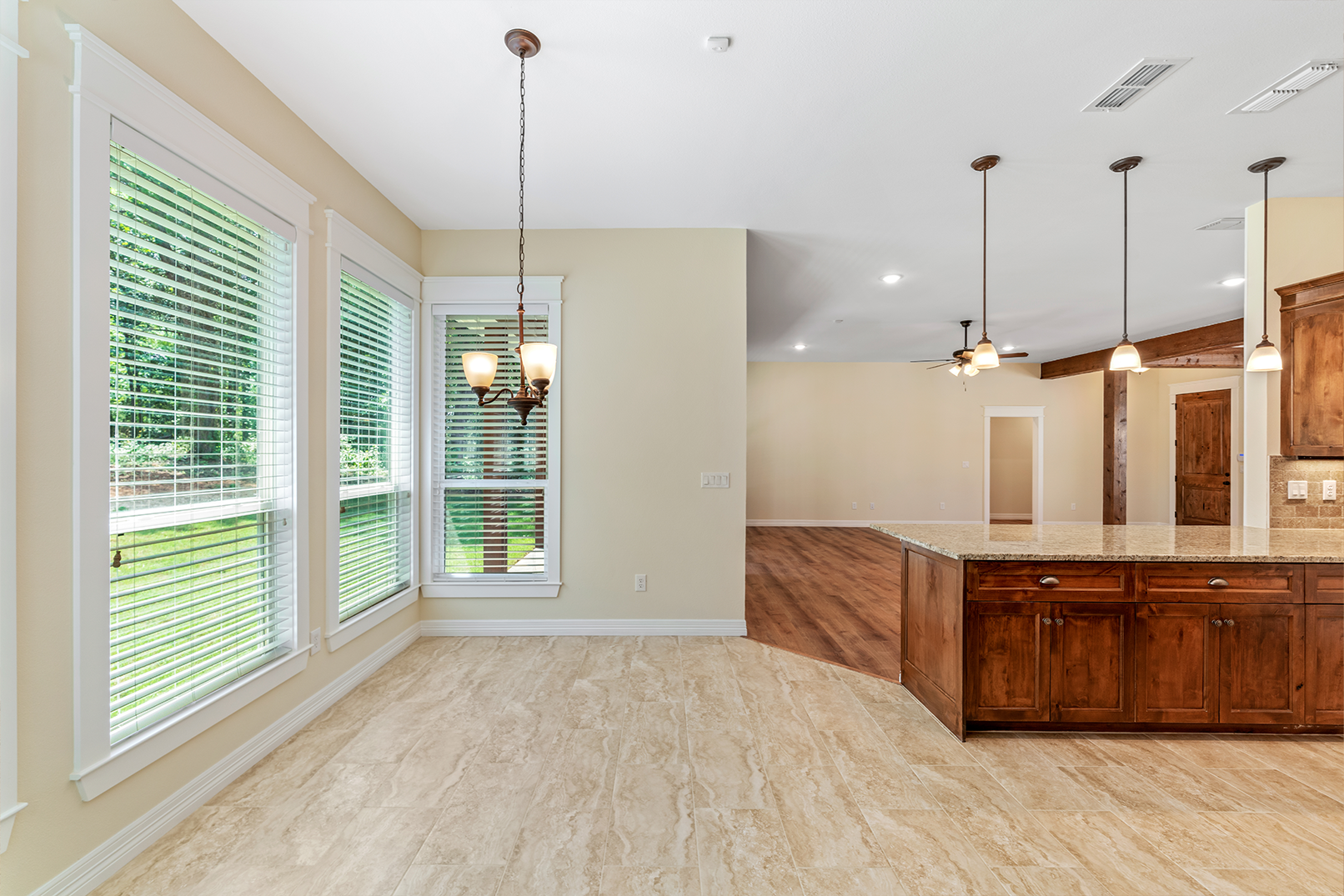 A kitchen and dining room in a house with a chandelier hanging from the ceiling.