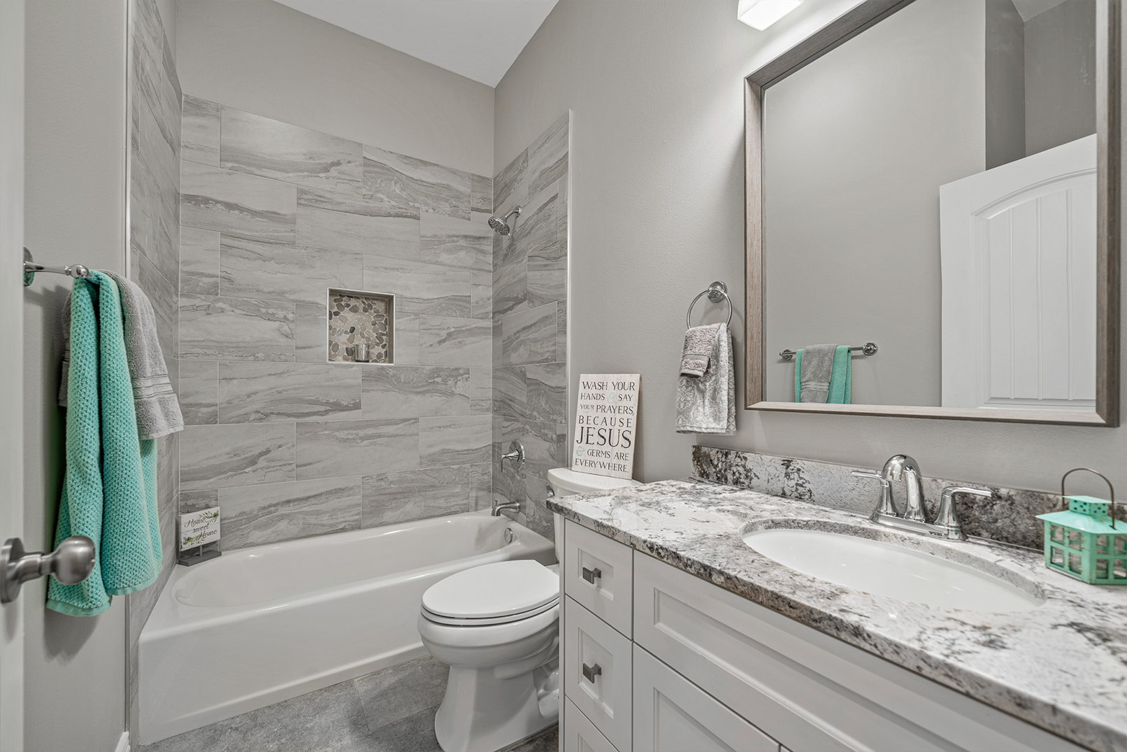 A bathroom with a sink , toilet , bathtub and mirror.