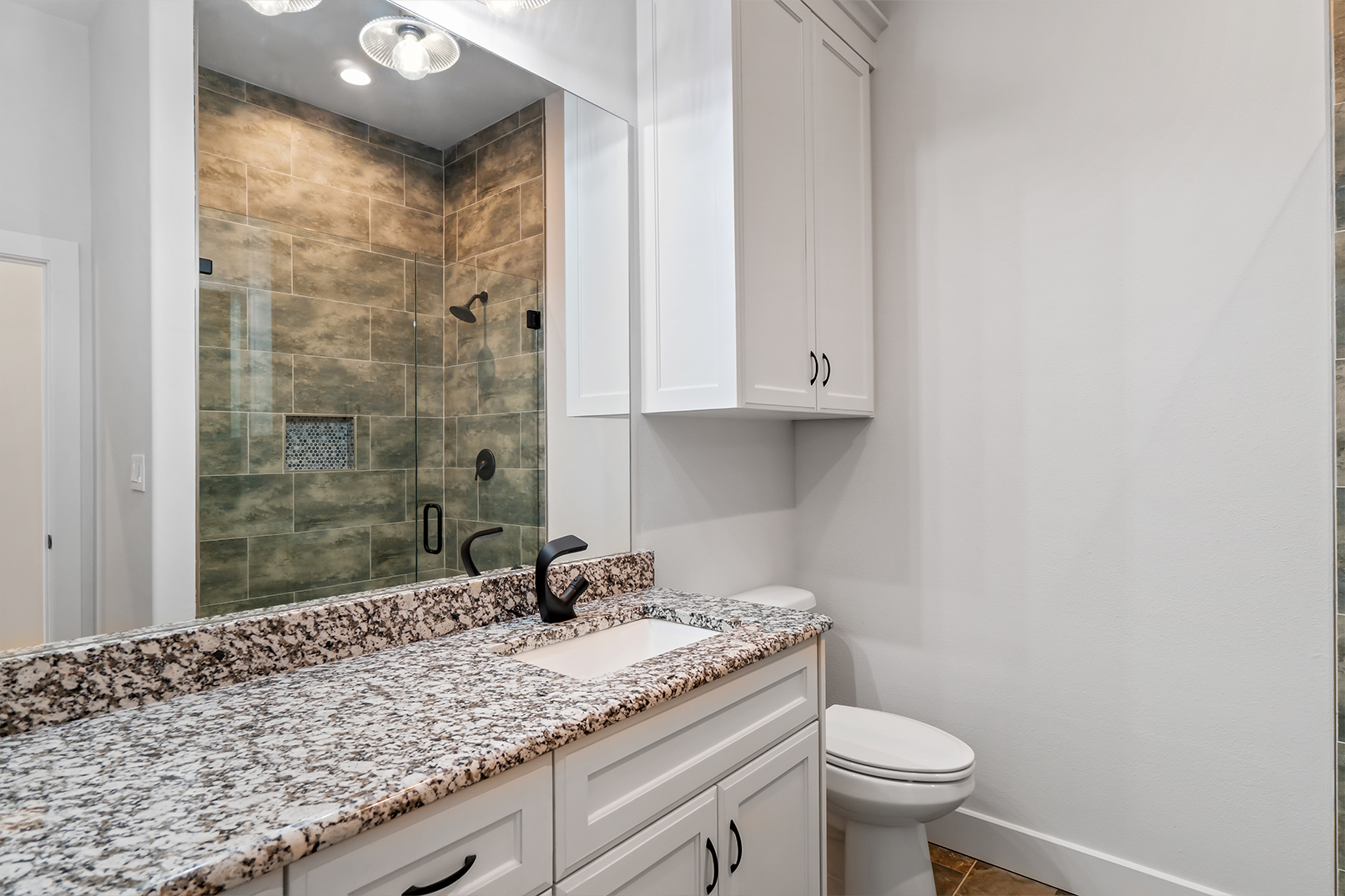 A bathroom with a sink , toilet and shower.