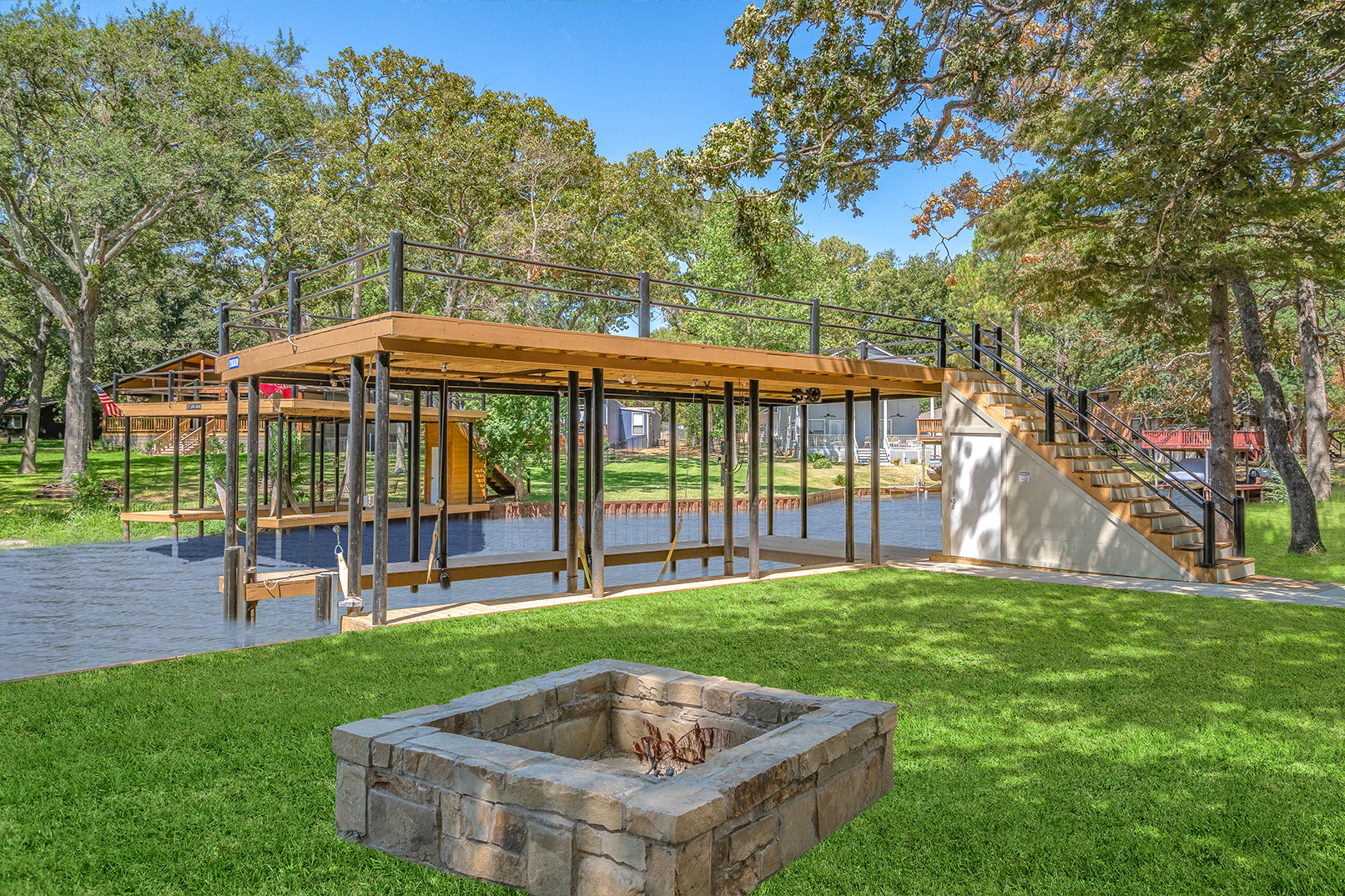 There is a fire pit in the middle of the grass in the park.
