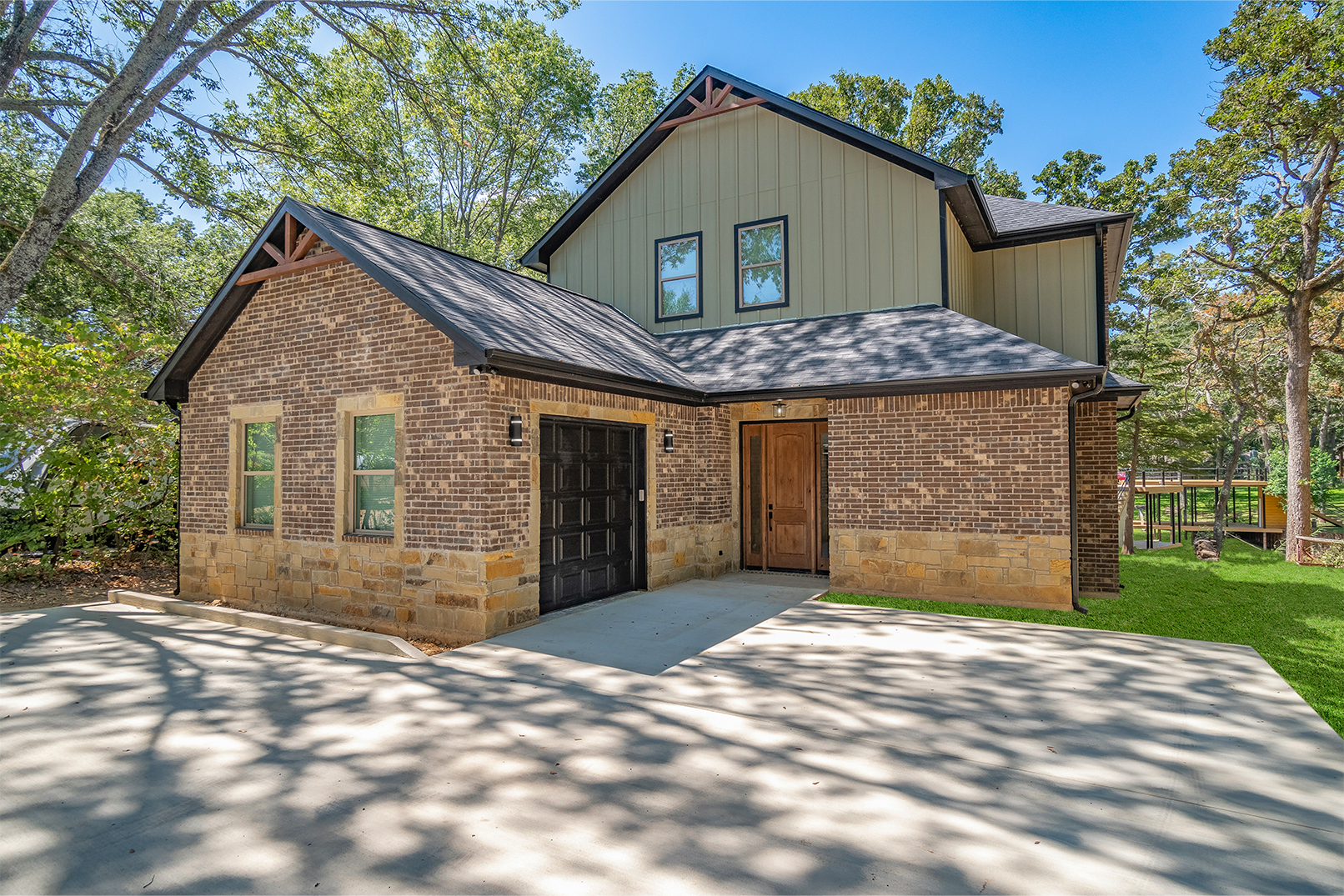 A large brick house with a garage and a driveway in front of it.