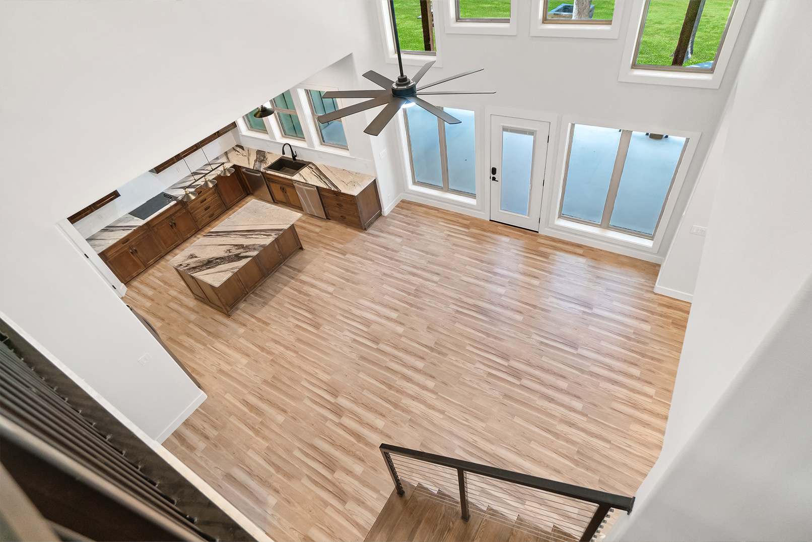 An aerial view of a living room with hardwood floors and a ceiling fan.