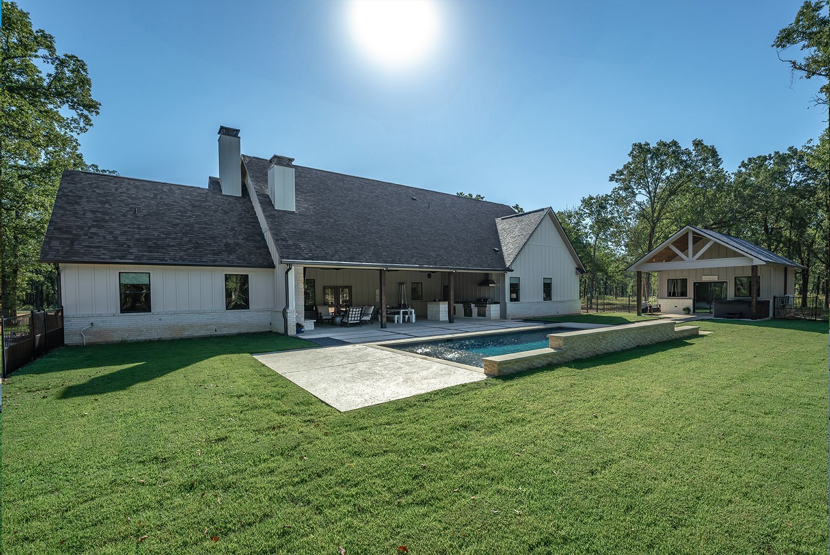 A large white house with a swimming pool in the backyard.