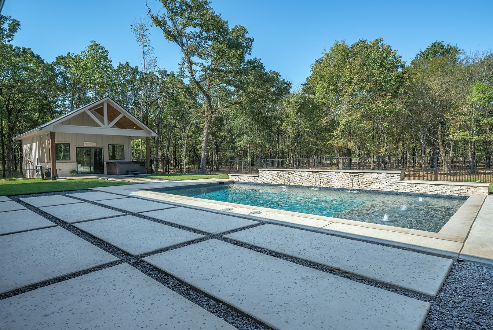 A large swimming pool with a house in the background