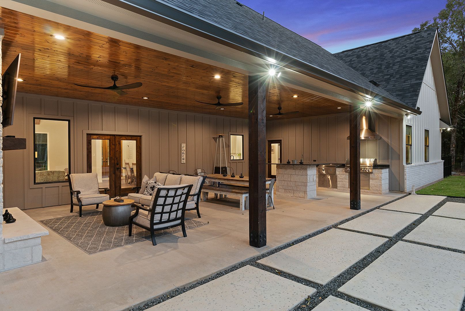 A large covered patio area with furniture and a ceiling fan.