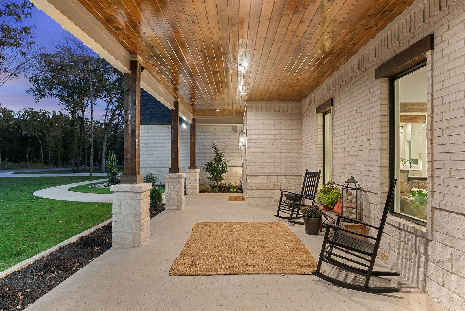 There are rocking chairs on the porch of a house.