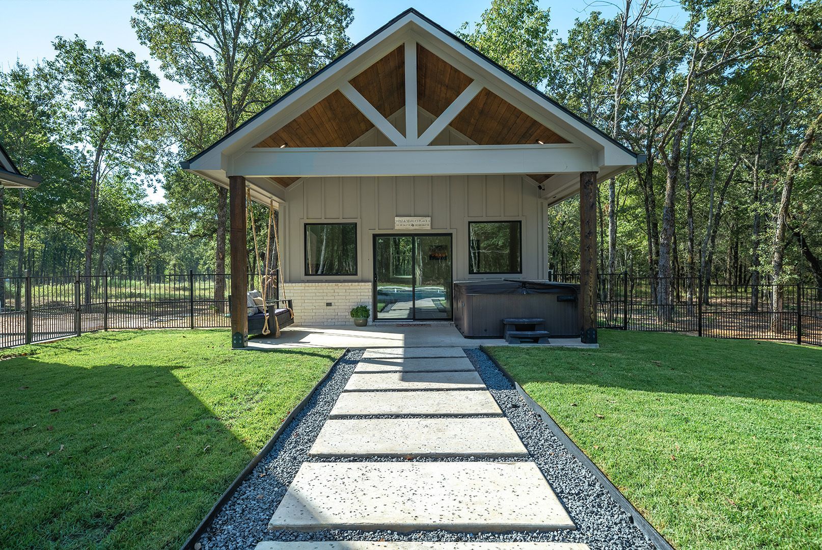 A house with a hot tub in the backyard and a walkway leading to it.