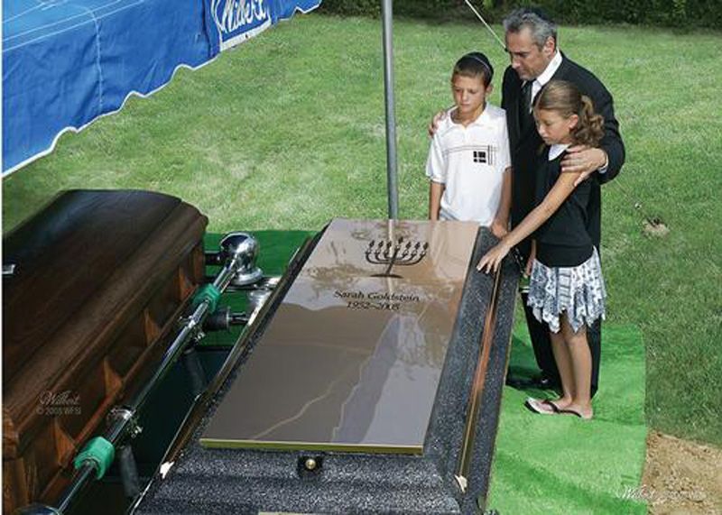 a man and two children are standing next to a coffin