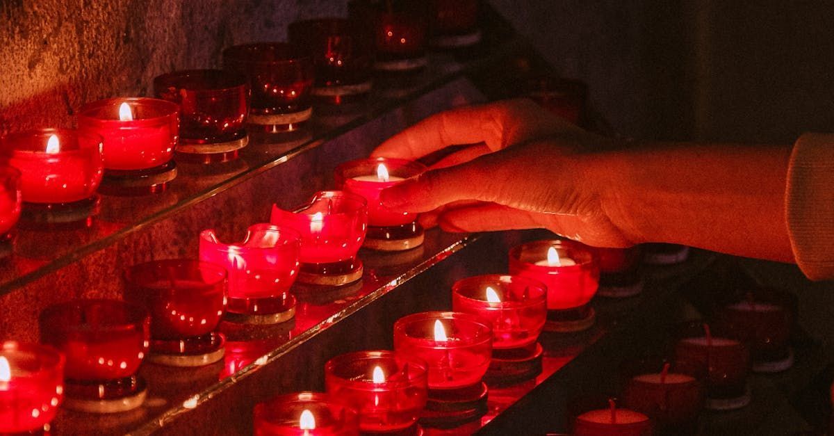 Hand lighting memorial candles during a remembrance ceremony for funeral and cremation services