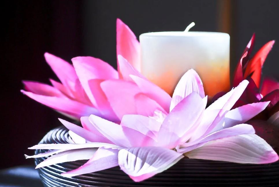 Lit candle nestled among pink lotus-style blooms for a custom memorial, Indianapolis, IN funeral hom