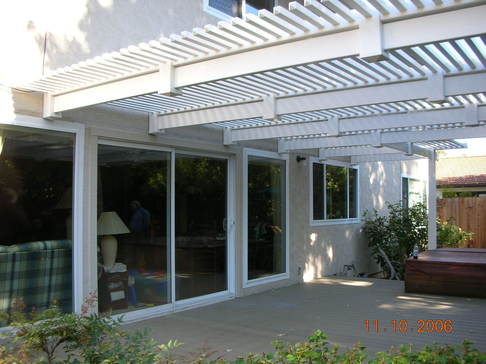 A patio with a pergola and sliding glass doors