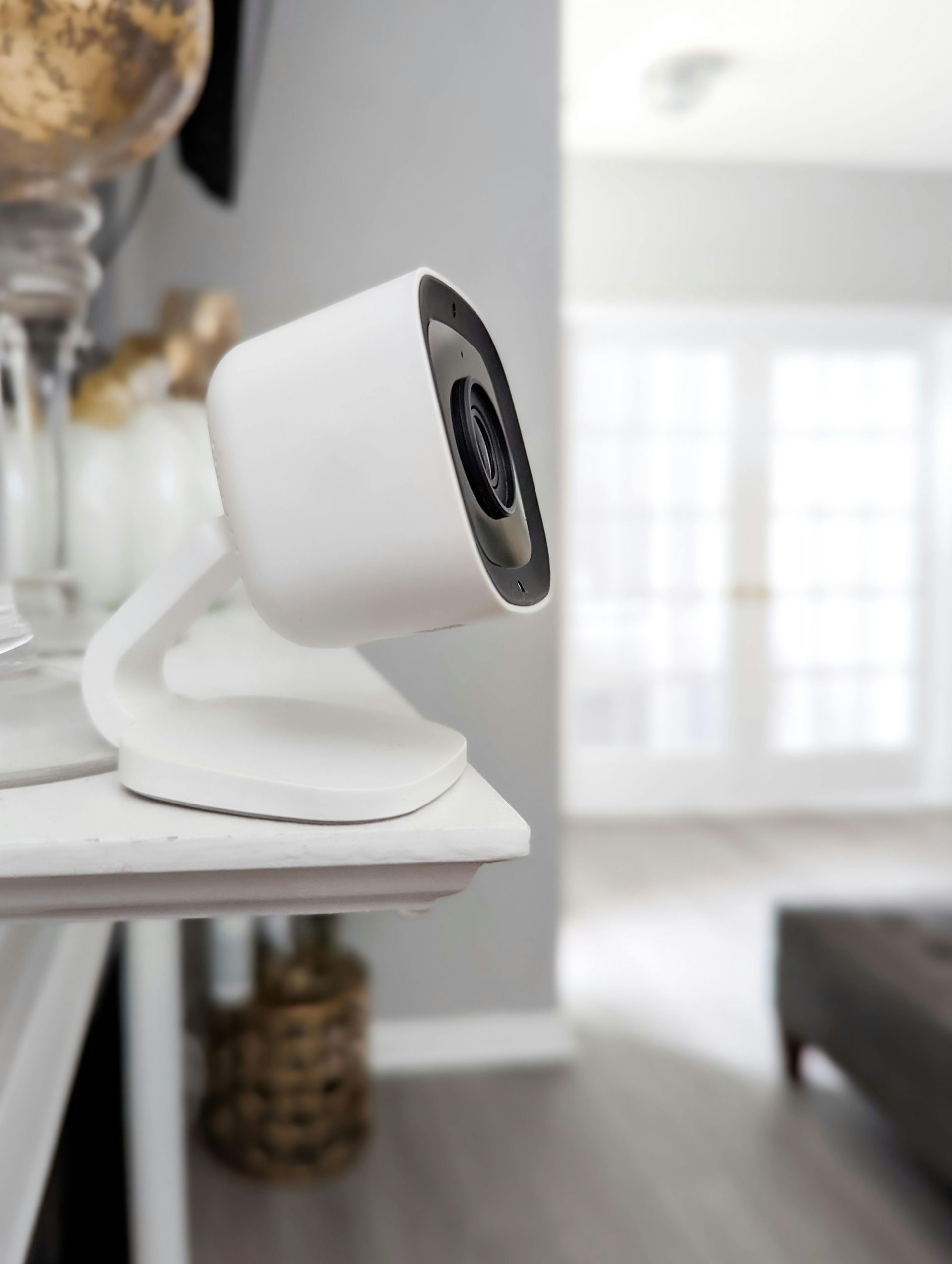 A white camera is sitting on a table in a living room.