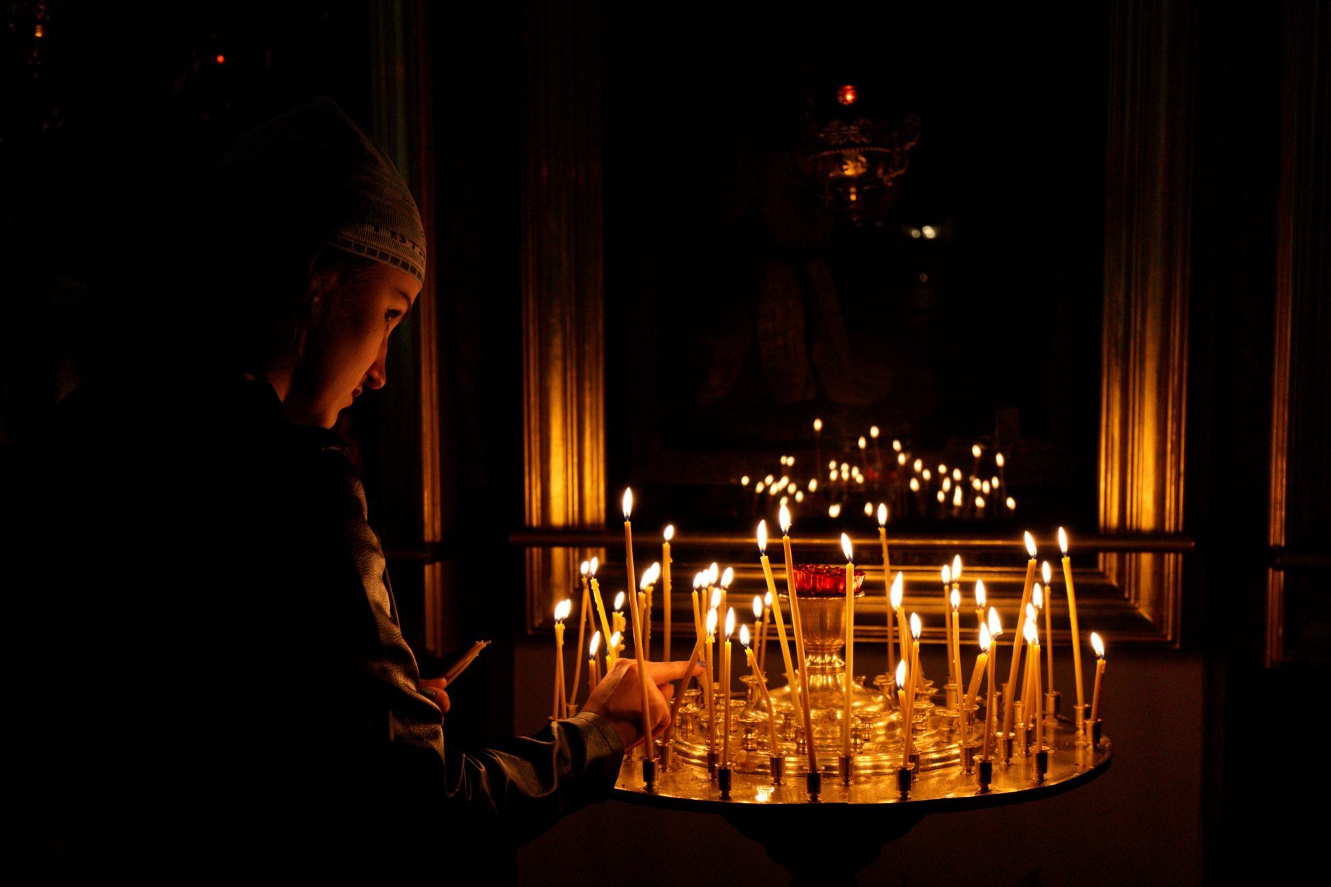 Orthodox woman lighting a candle 