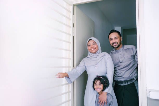 Muslim family standing in doorway smiling