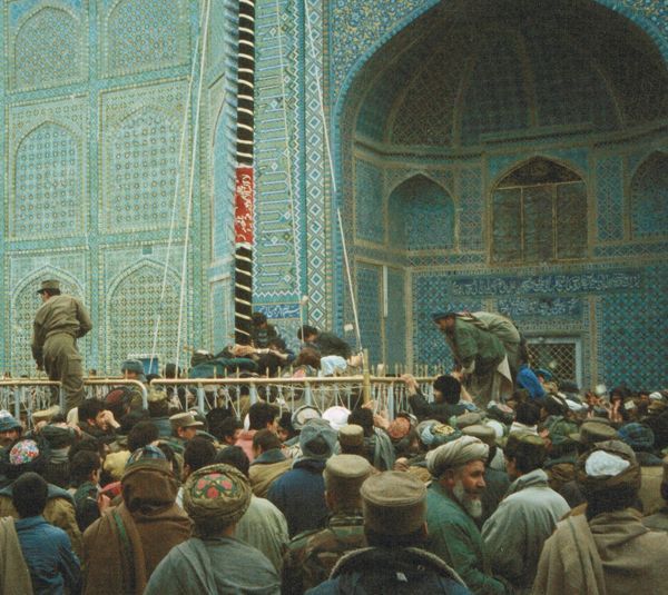 People jumping the fence around the Nauroz pole. 