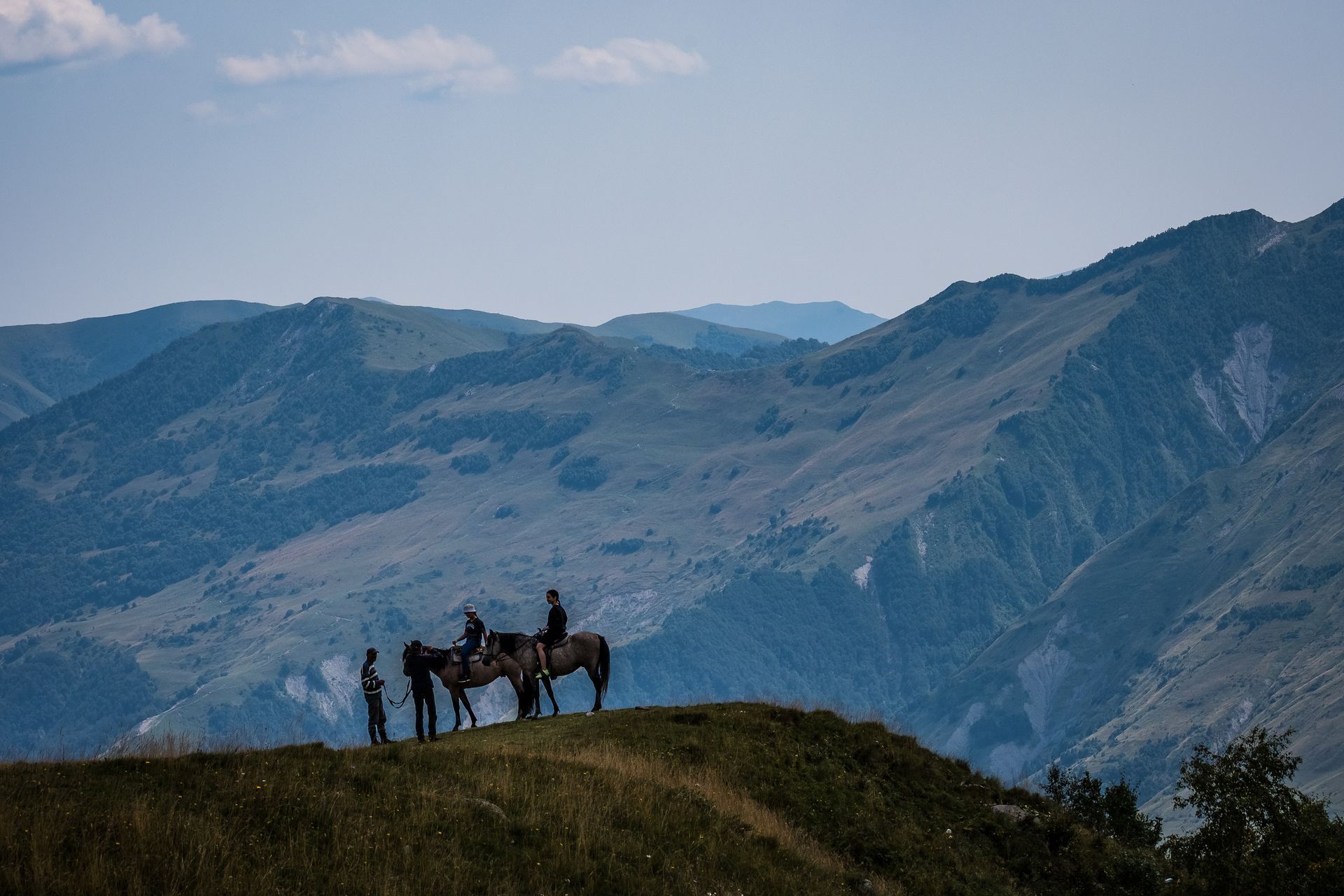 People riding horses on a mountain range