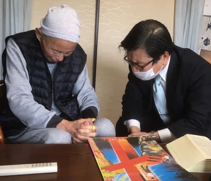 Japanese man prays with his pastor during COVID-19.