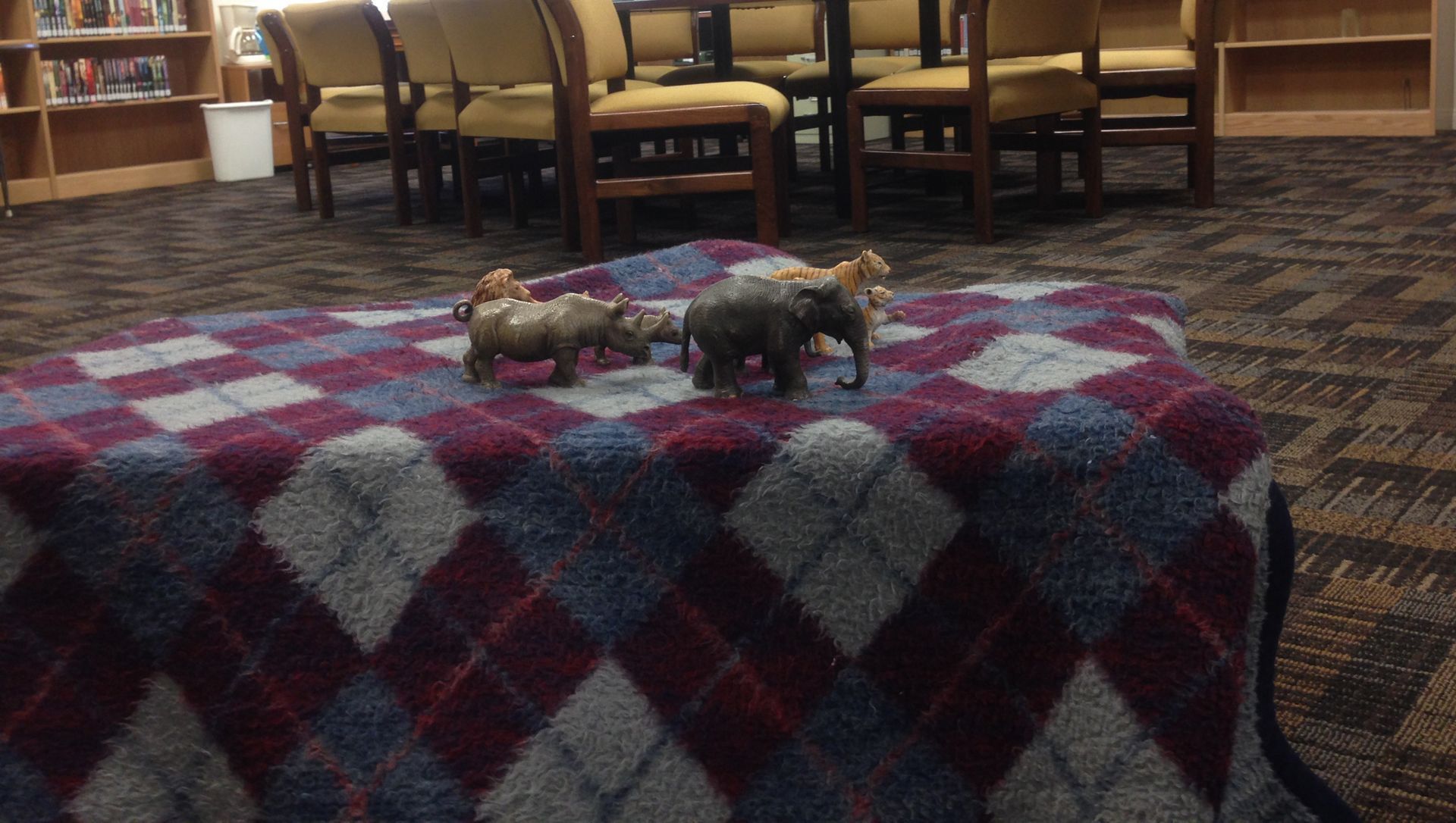 An obstacle-course “cave” made out of a blanket in a church library. 