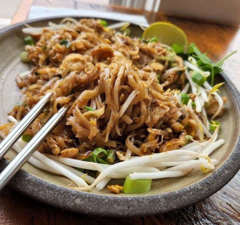 A close up of a plate of food with chopsticks on a table