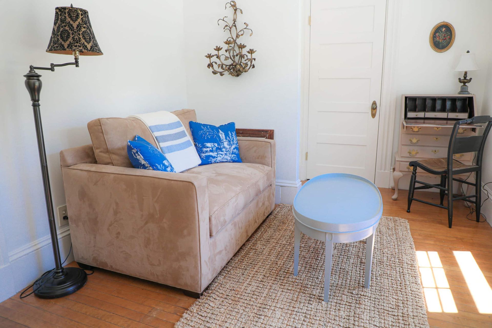 A living room with a couch , table and lamp