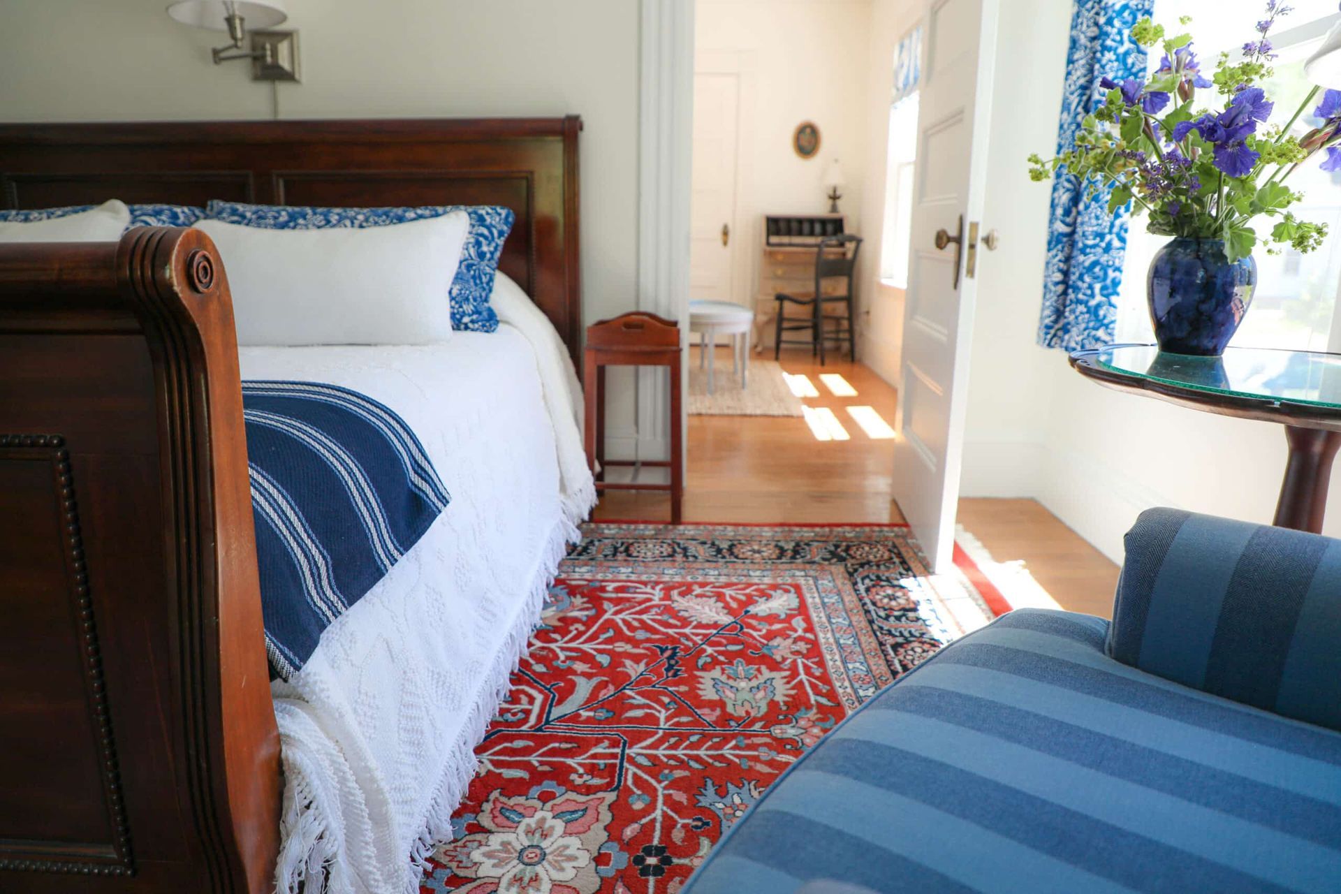 A bedroom with a sleigh bed and a blue chair