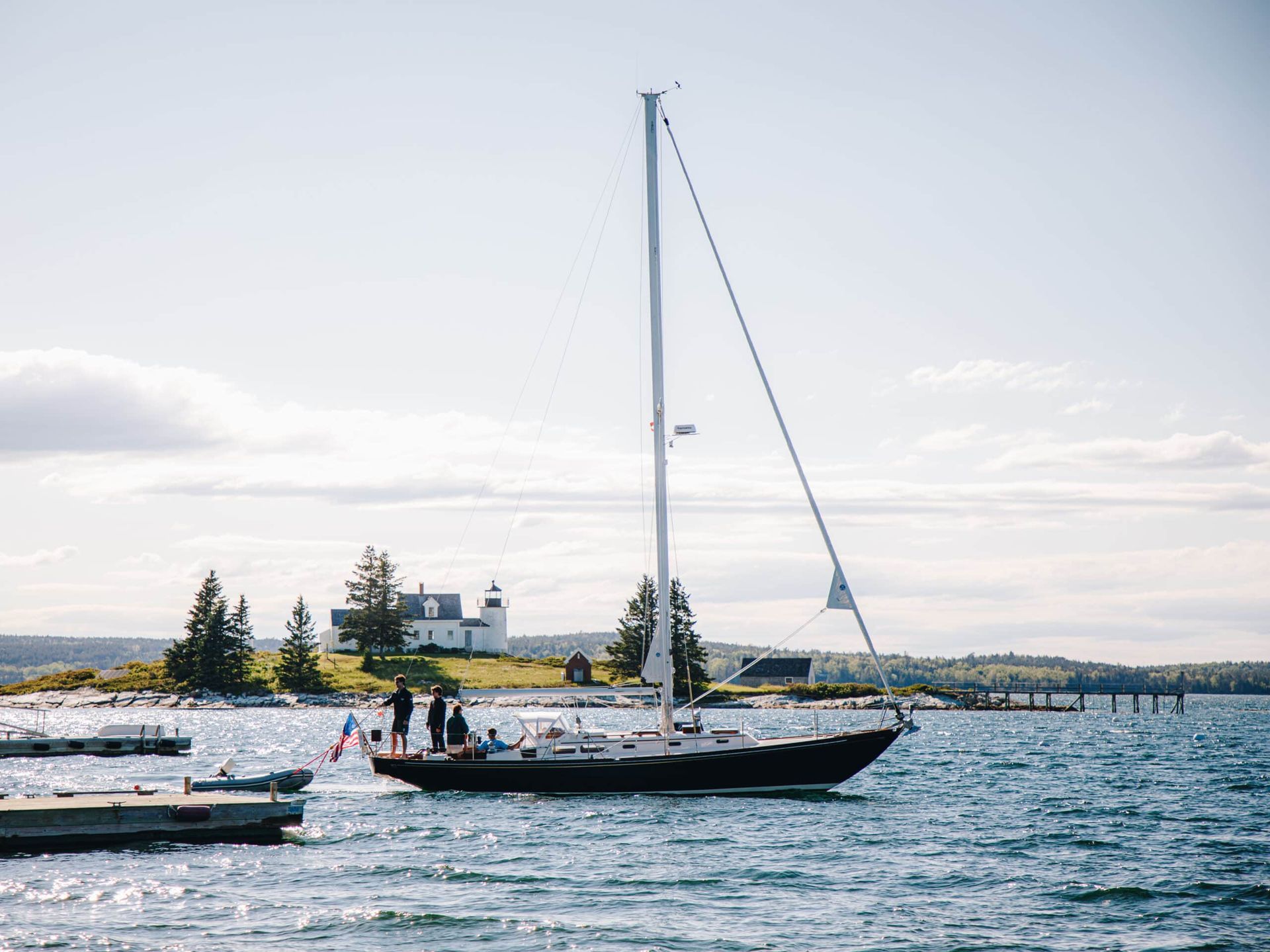 A sailboat is docked in the water near a small island.