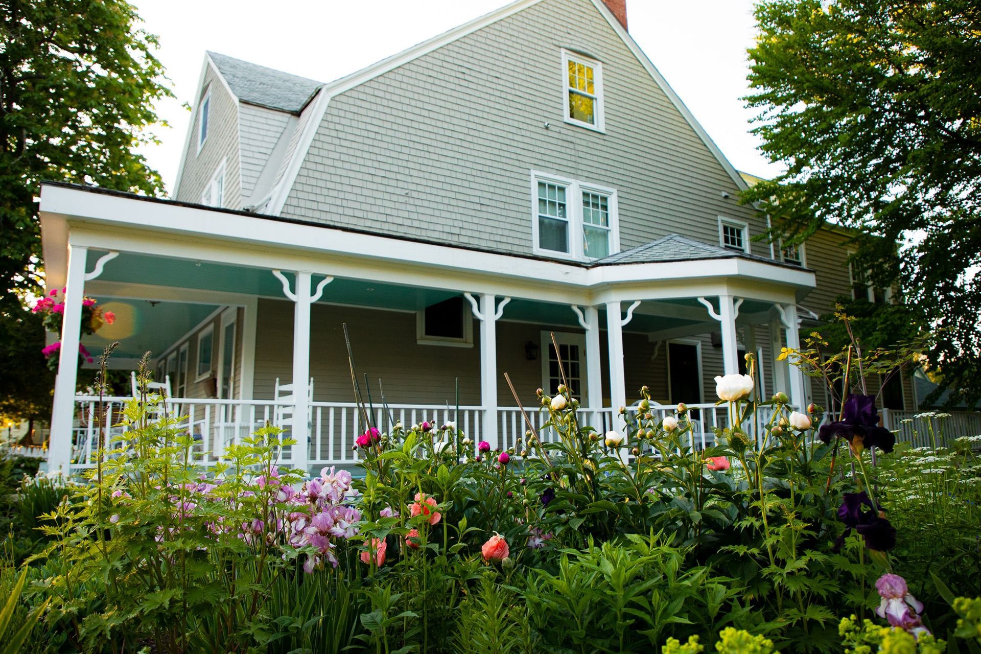 A house with a porch and flowers in front of it