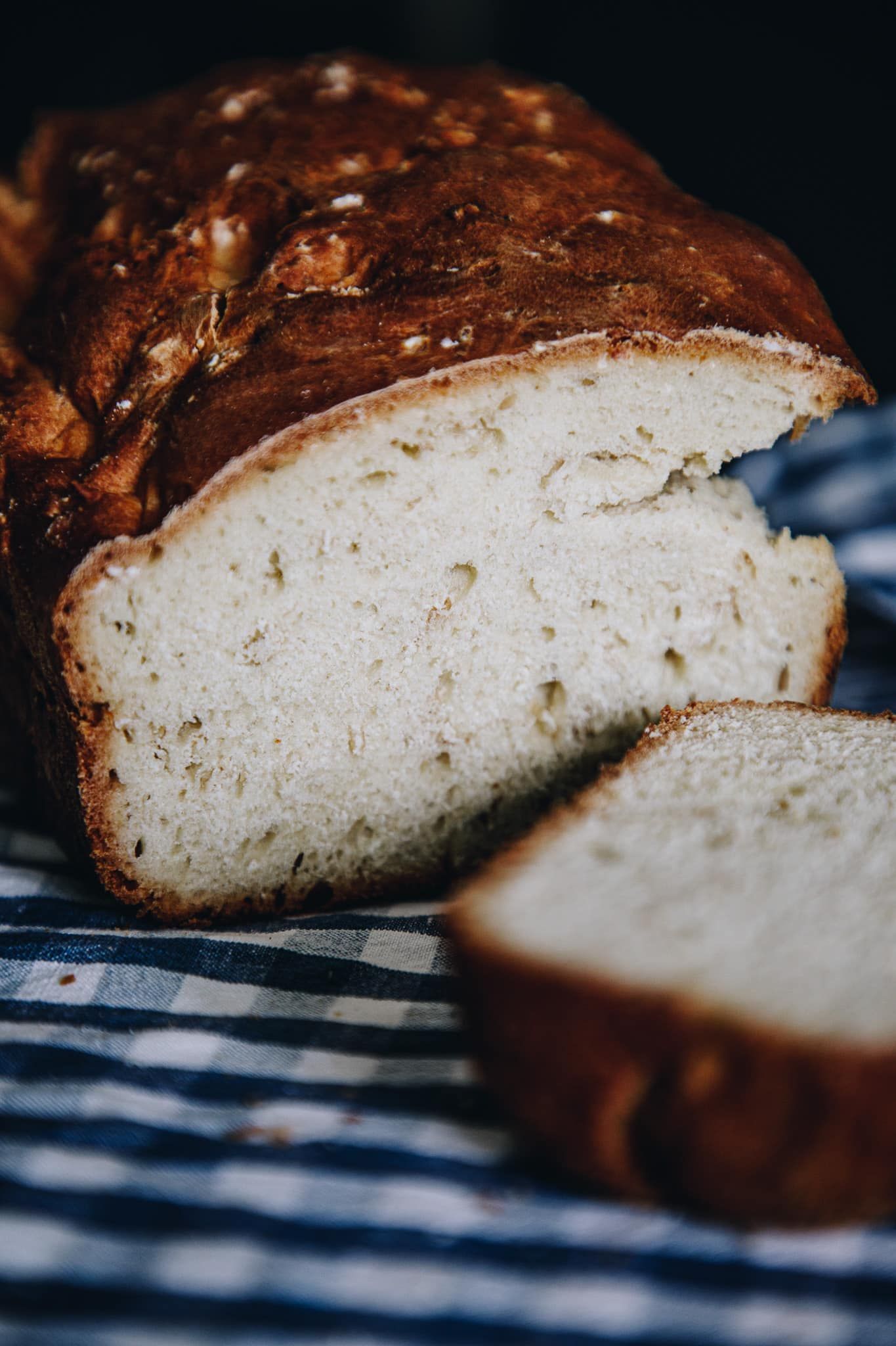 A loaf of bread is sitting on a table with two slices taken out of it.